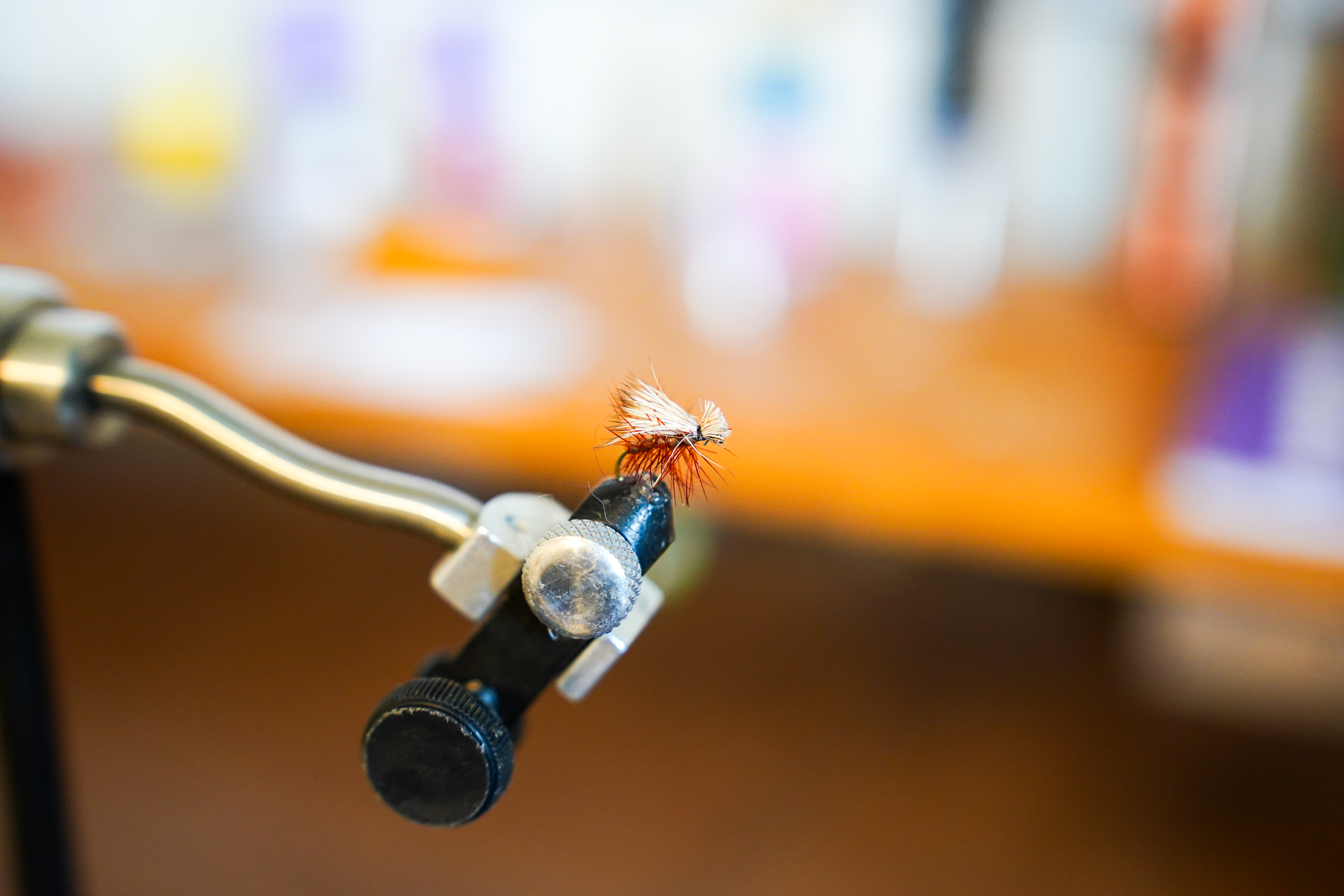 A close-up of an elk hair caddis in a vice.