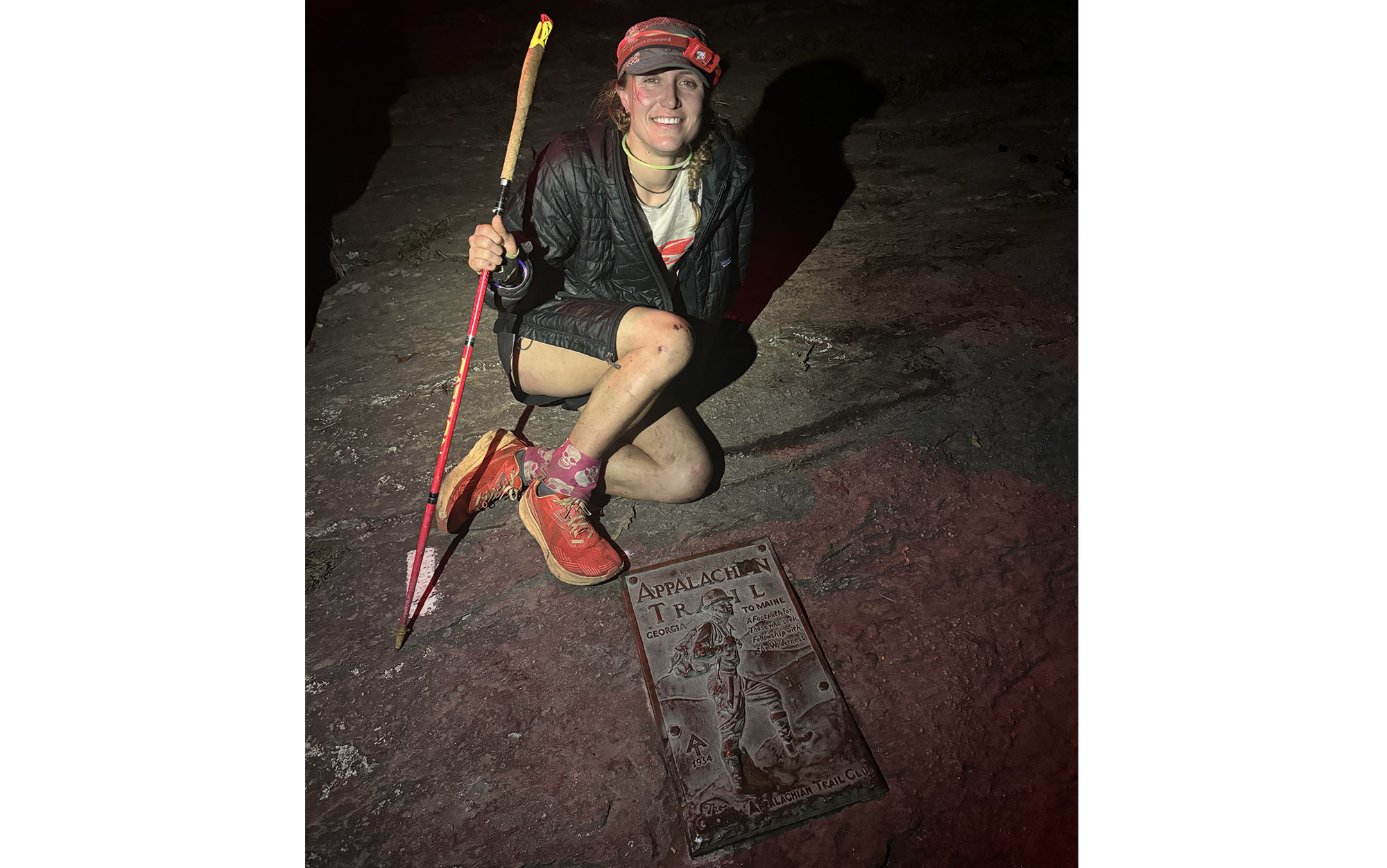 Tara Dower sitting behind the terminus plaque for the AT in Georgia.