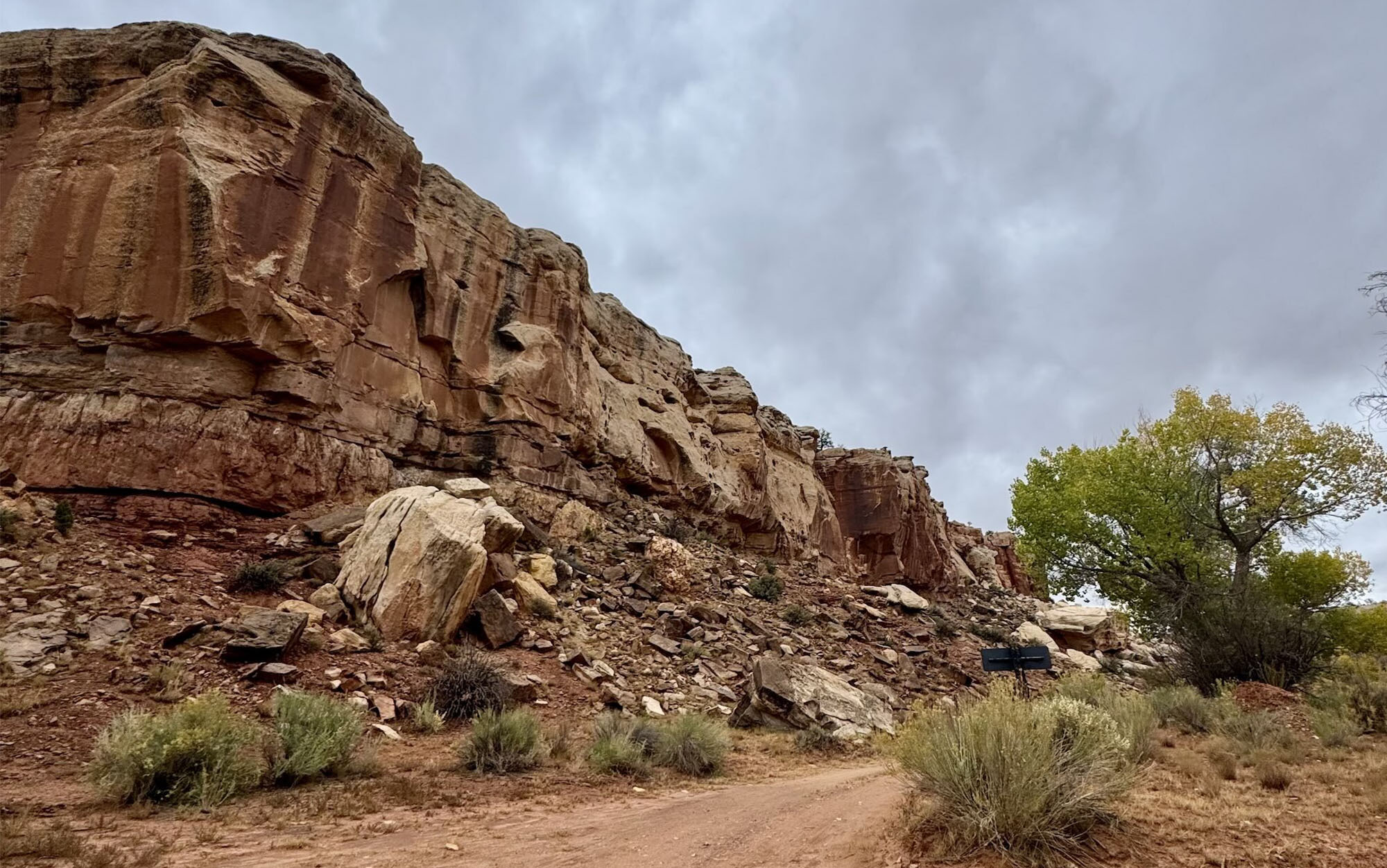 a dirt road running in front of one wall of a Utah desert canyon