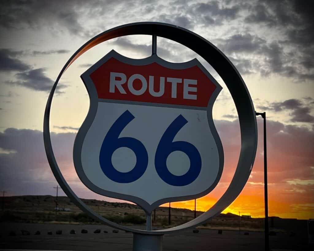 A Route 66 Highway sign at sunrise.