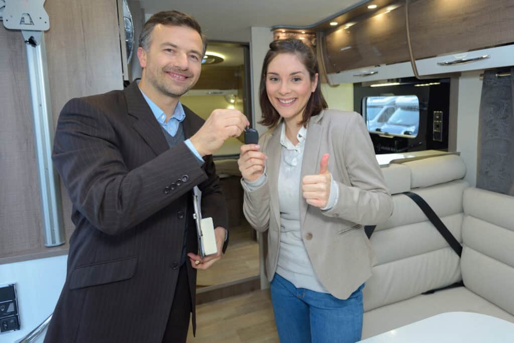 Woman about to buy an RV from a salesman