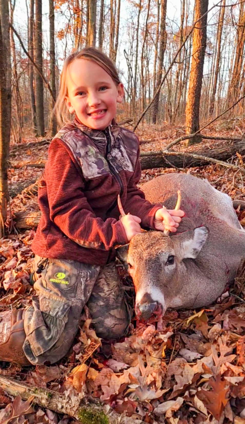 A young hunter with her buck.