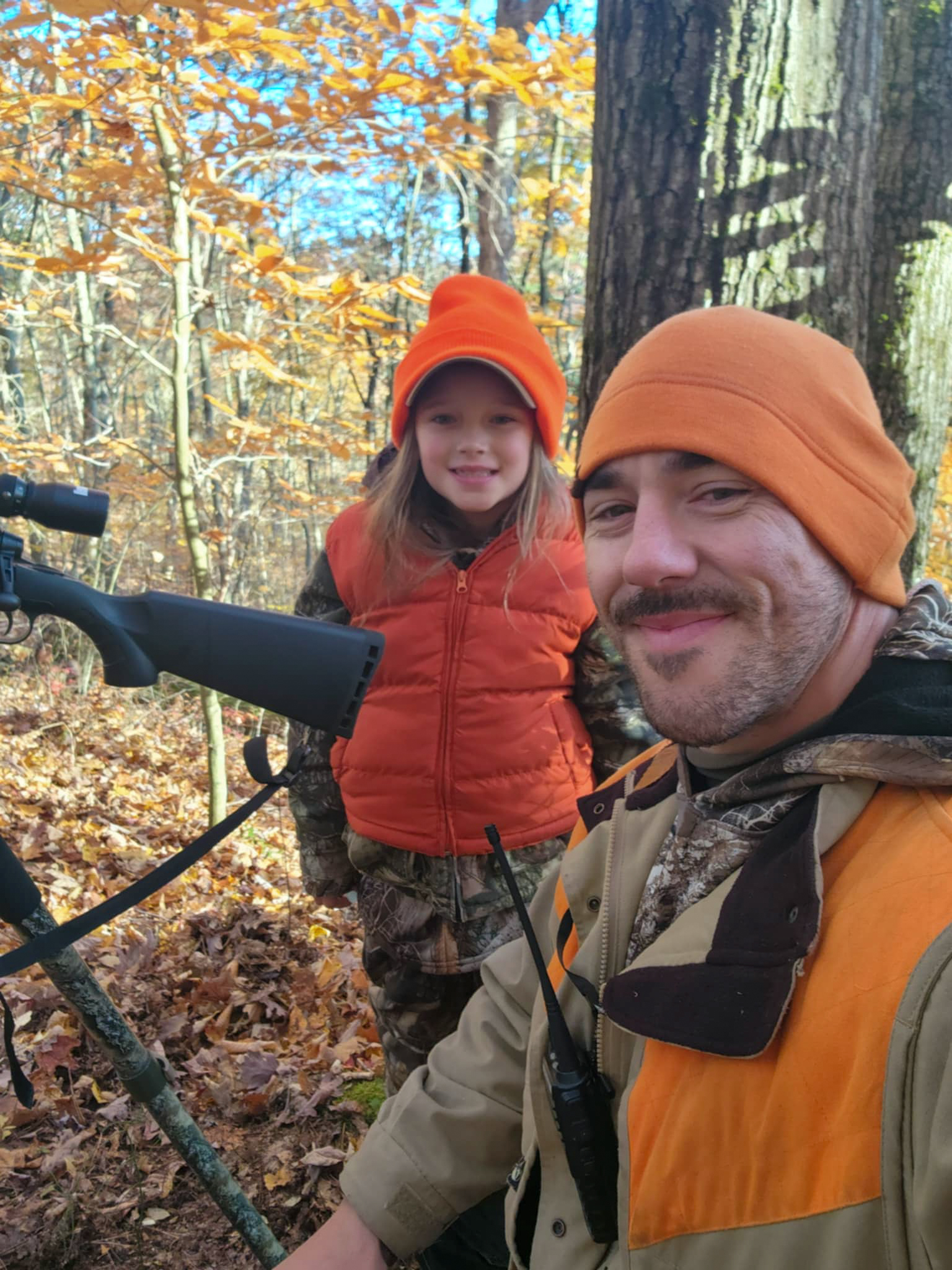 A father and daughter in blaze orange.