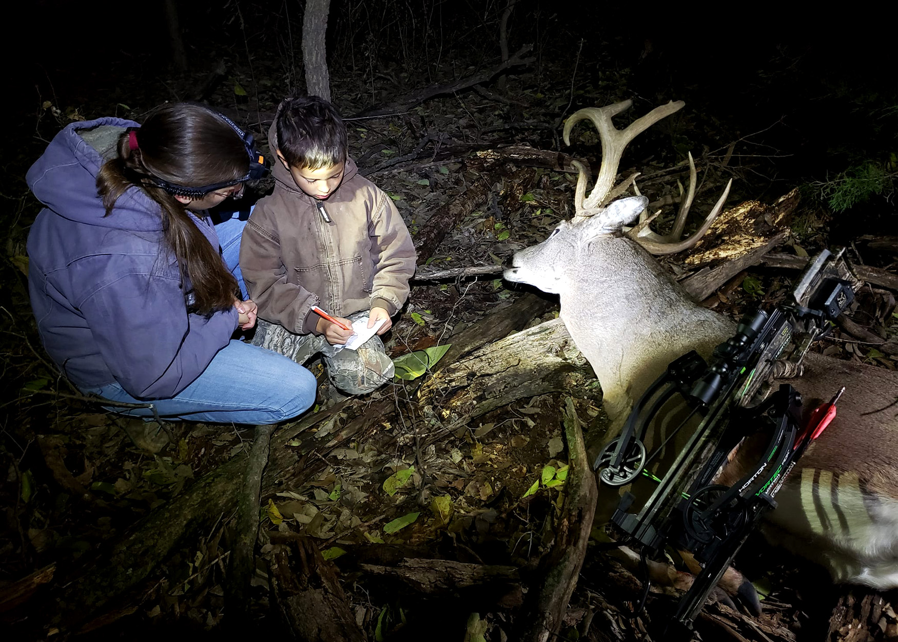 A youth hunter notches his tag on a buck.