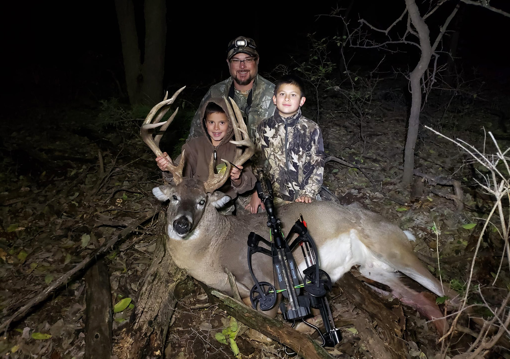 A father and his two suns with a Kansas buck.