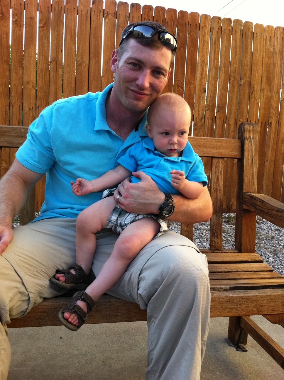 A man in a blue shirt holds a young baby. 