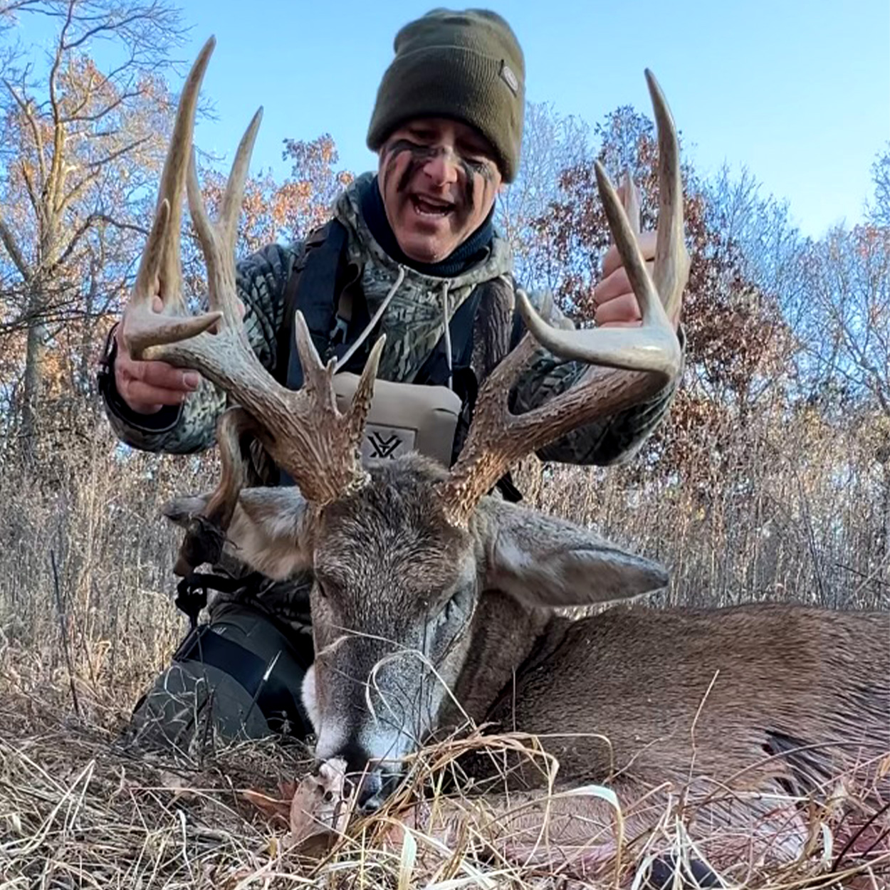 A bowhunter looks down at a big Missouri buck.