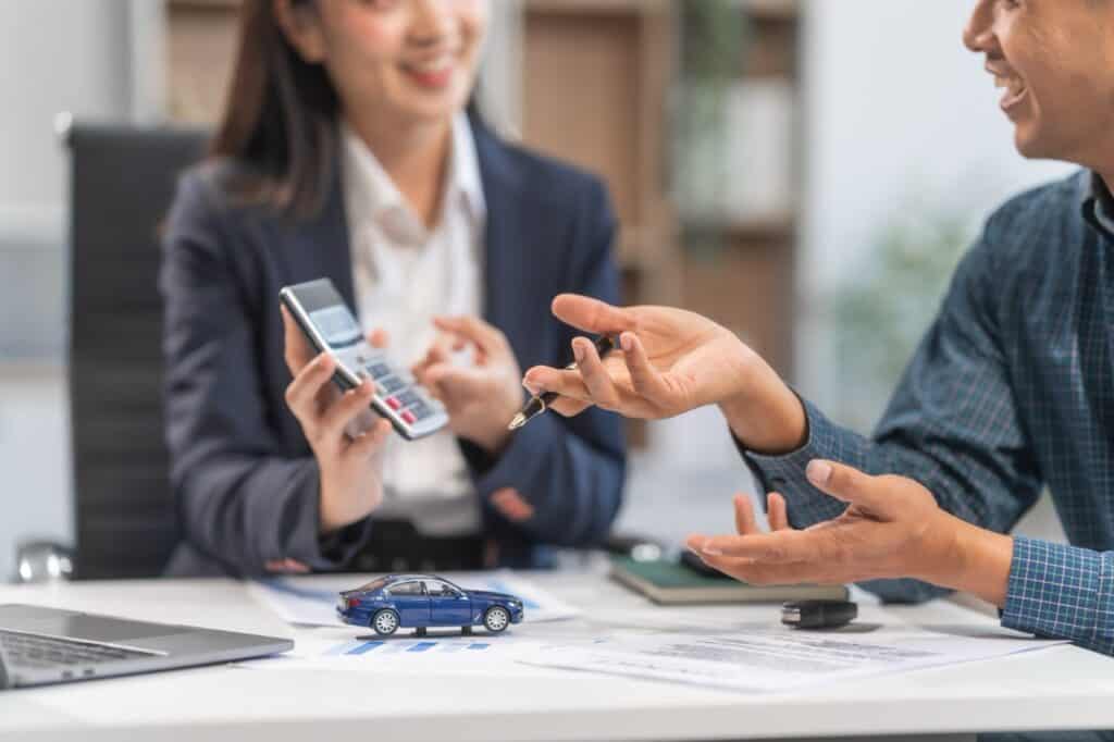 Man and woman looking at a calculator discussing RV insurance.