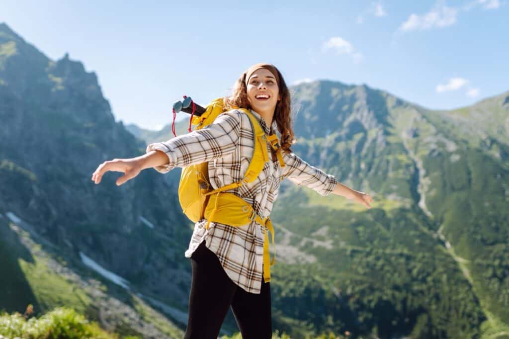 A woman hiking near a mountain.