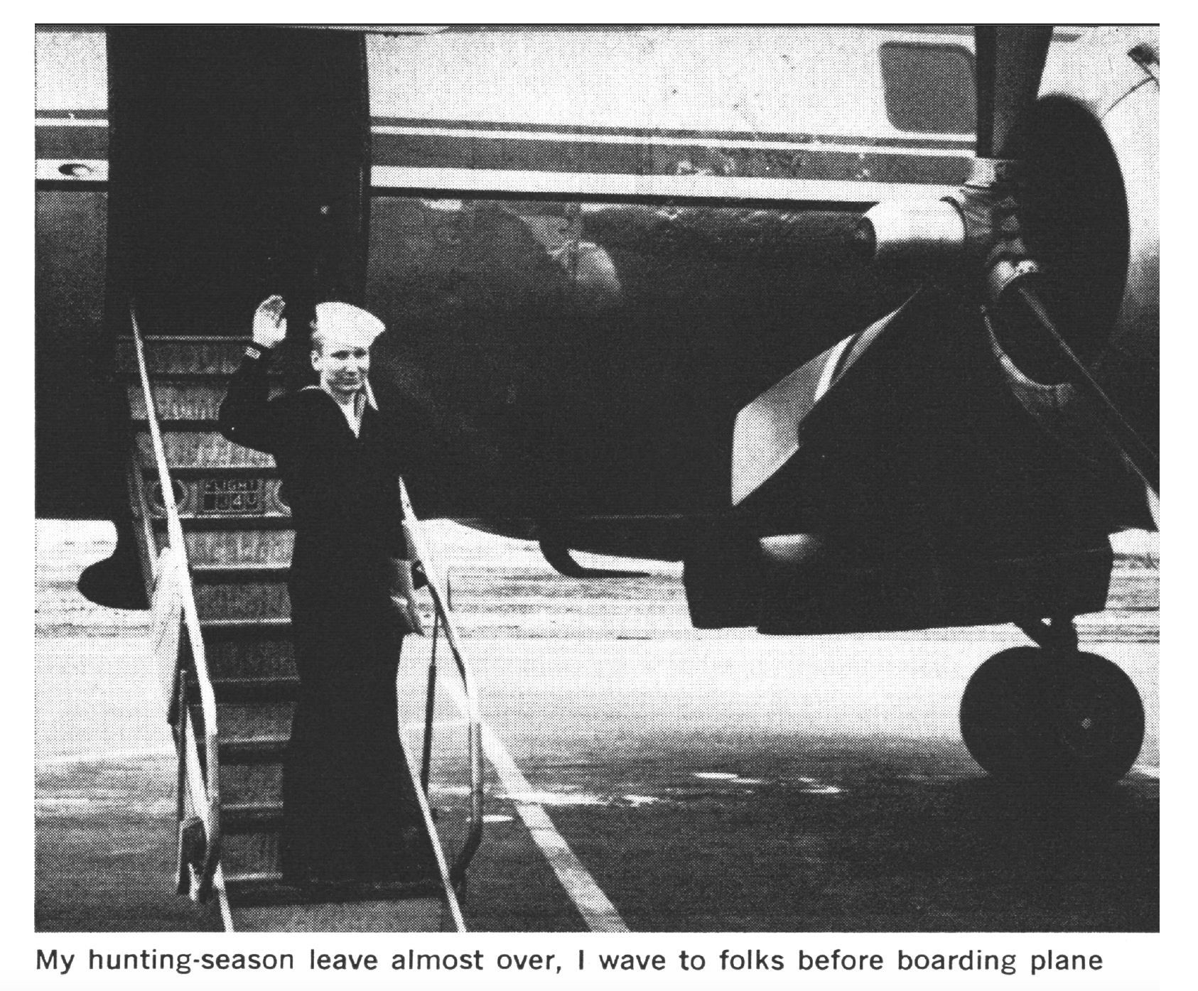 A sailor waves before stepping onto a plane in a black and white photograph