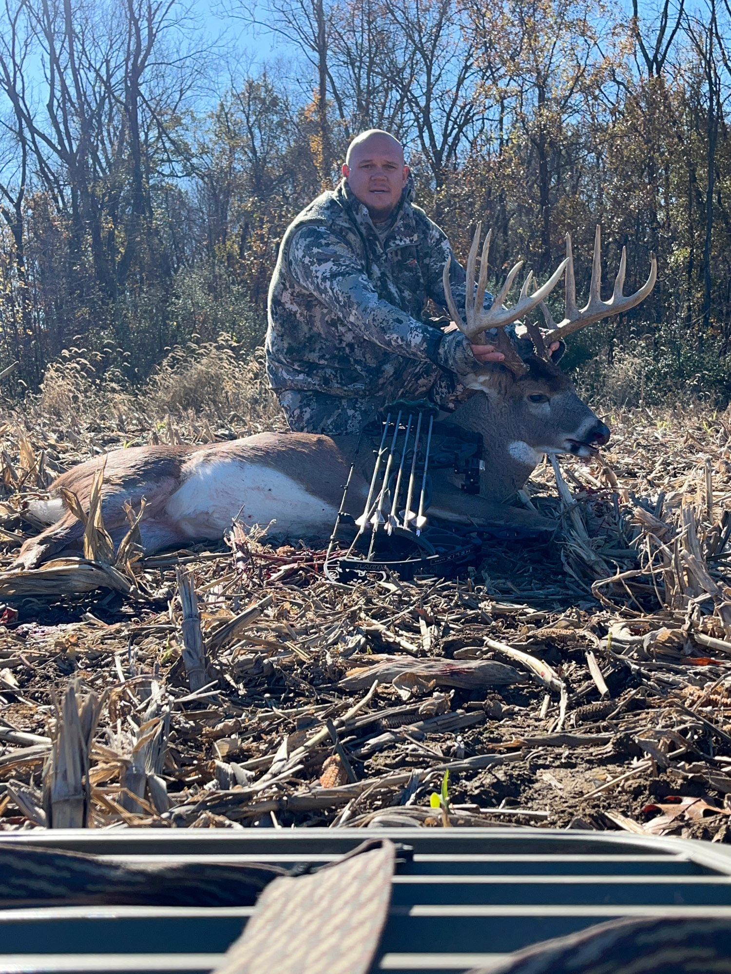 A bowhunter with a big typical buck.