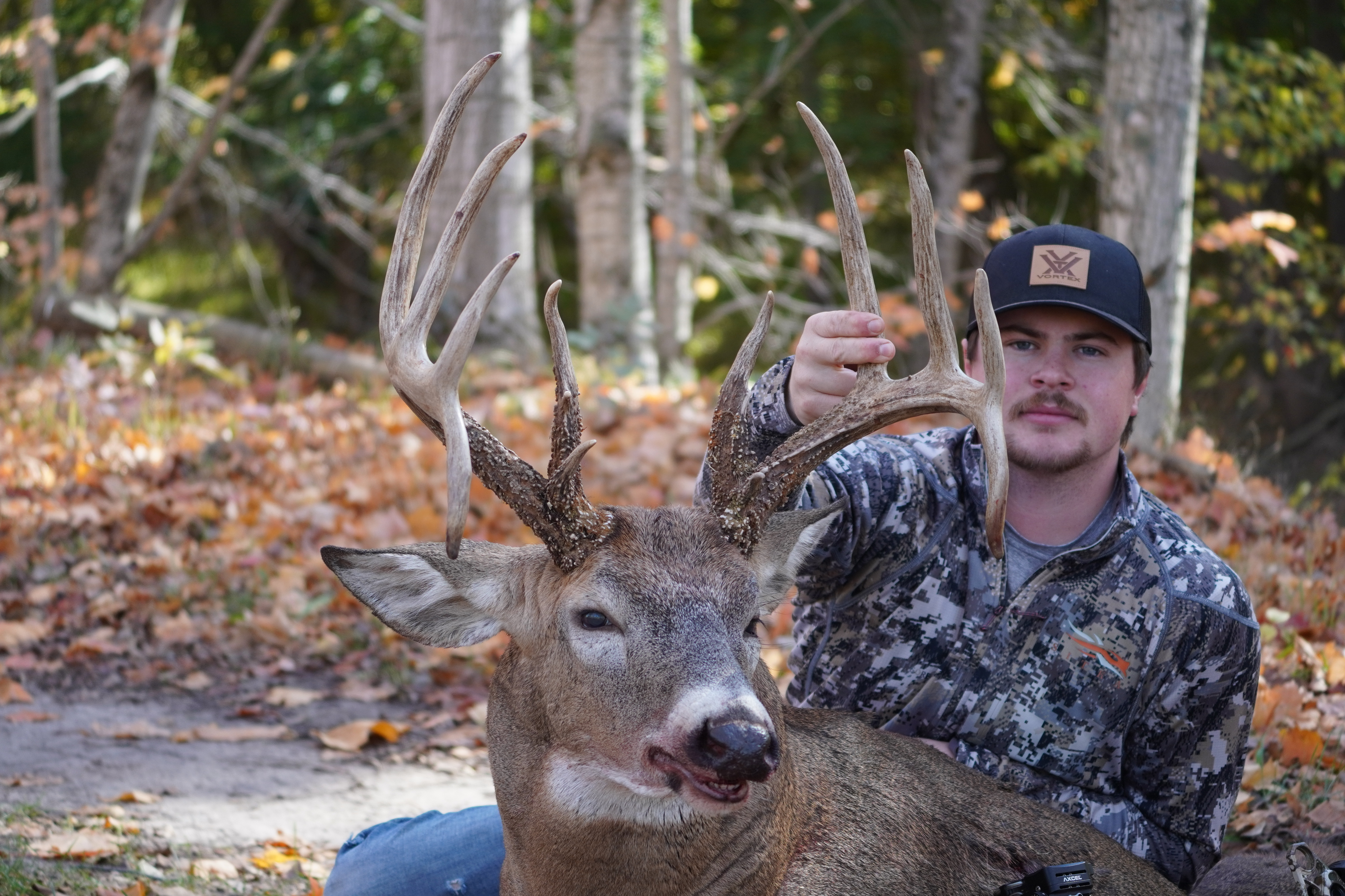 Hunter holds unique 13-point buck with curved drop tines.