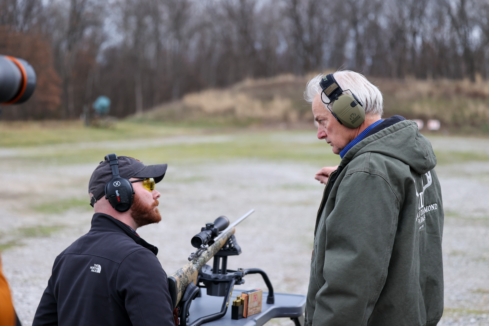 Two men talk at the range.