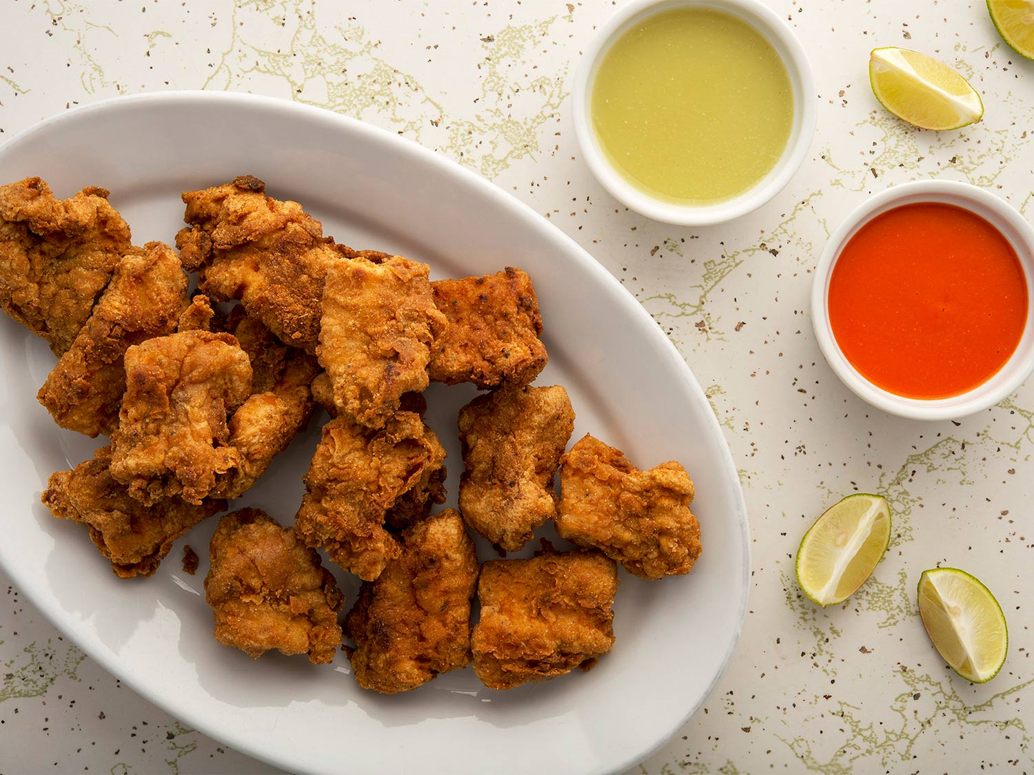 Nuggets of fried bass served with lemon and sauces.