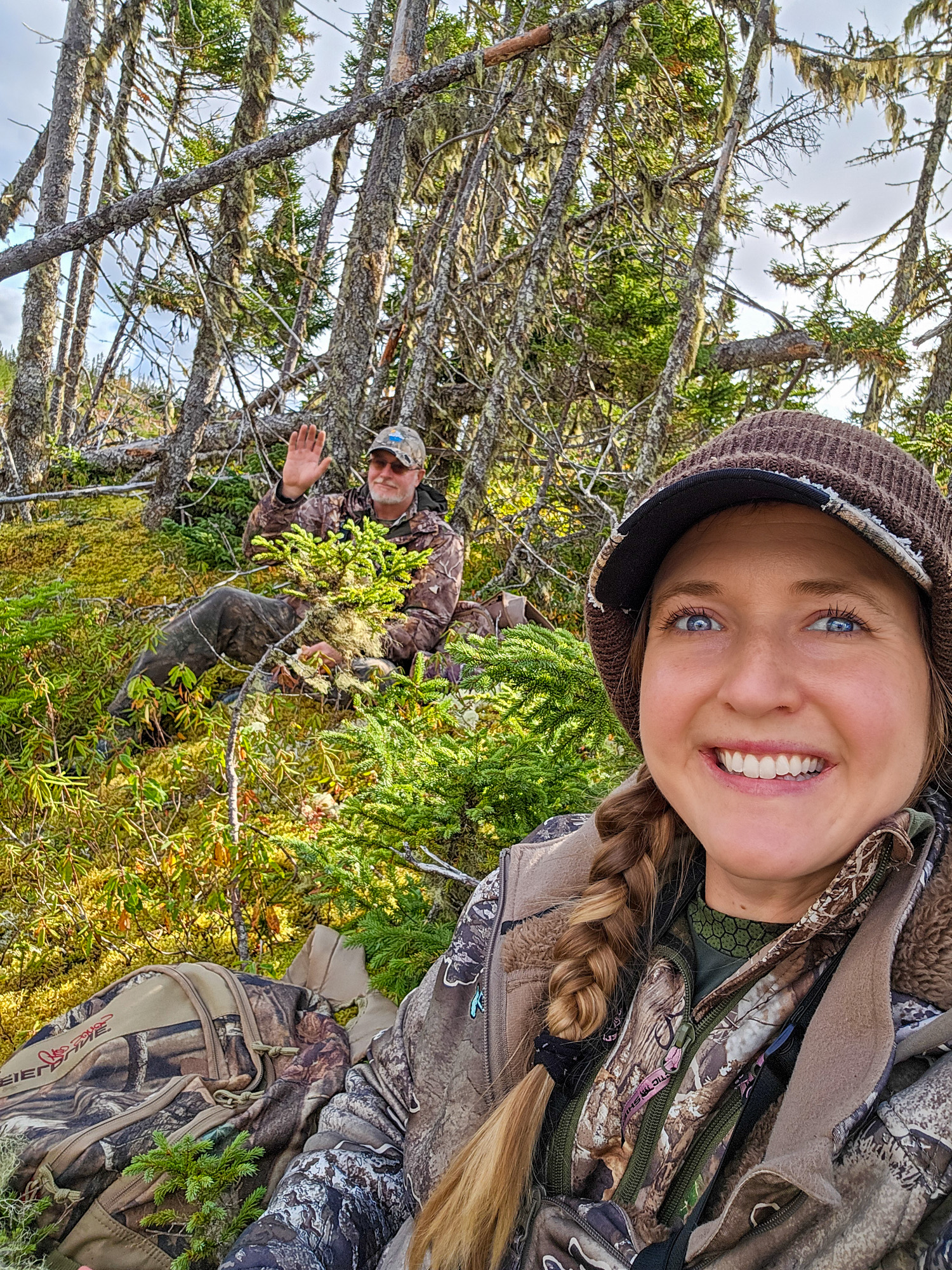 A hunter takes a selfie in the woods.