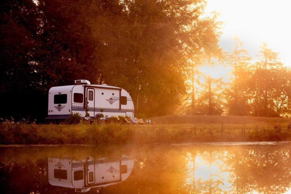 A sunset image of a Gulf Stream travel trailer near a lake. Photo courtesy Gulf Stream.