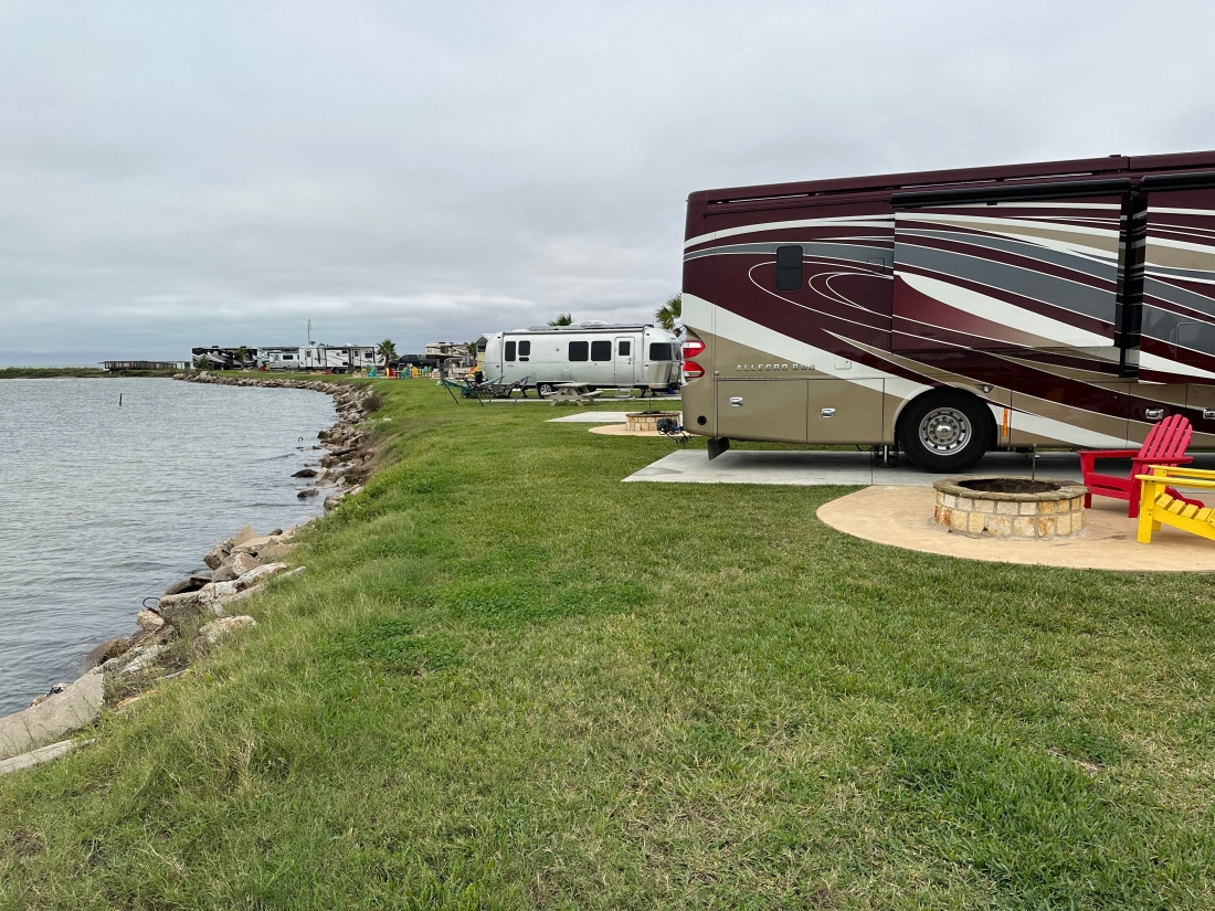 Motorhome and Airstream trailer on waterfront campsites at Firefly RV Park Corpus Christi.