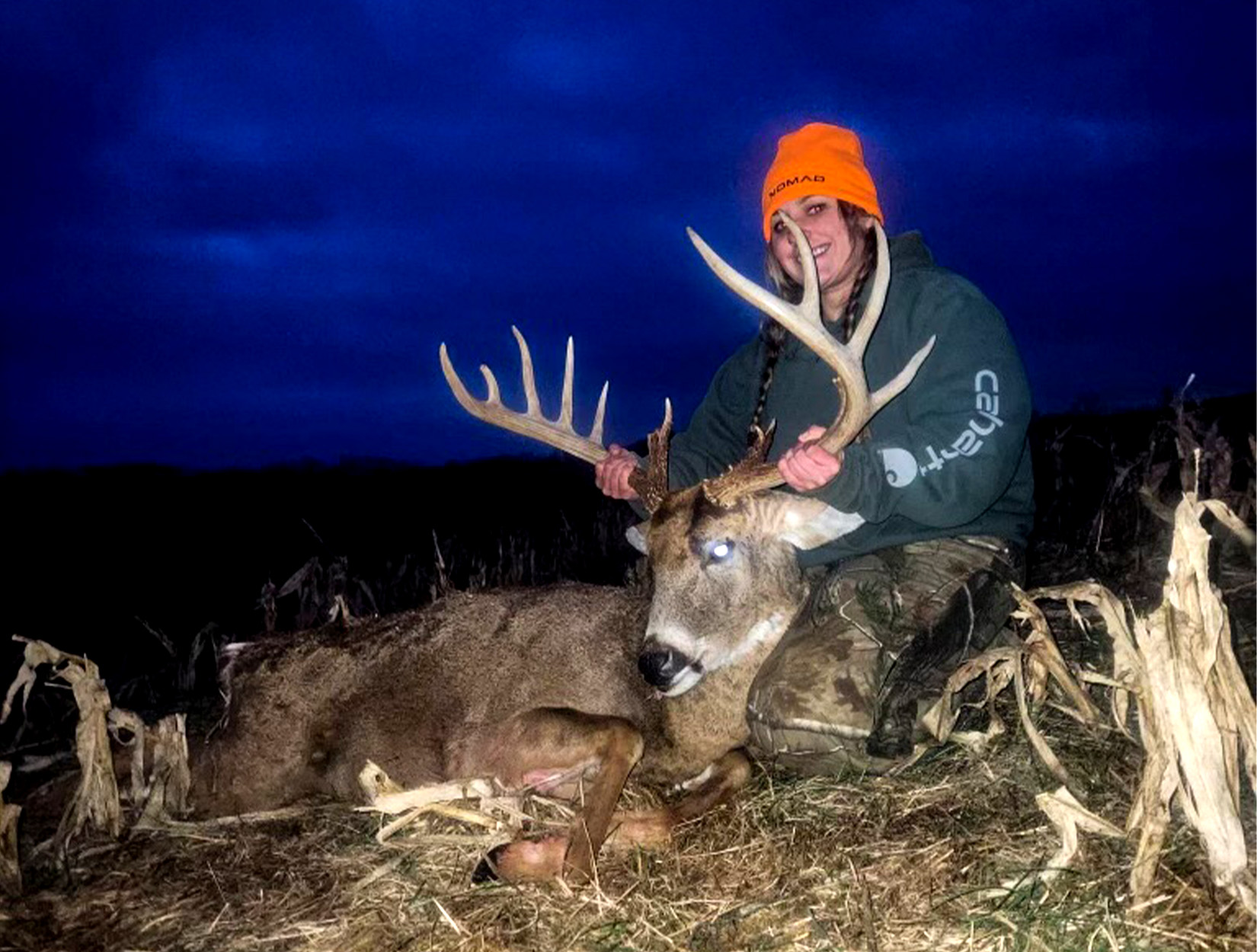 A Pennsylvania hunter with a buck at dusk.