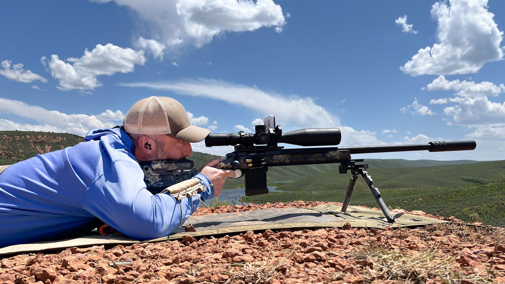 Shooting editor John B. Snow lies behind a rifle