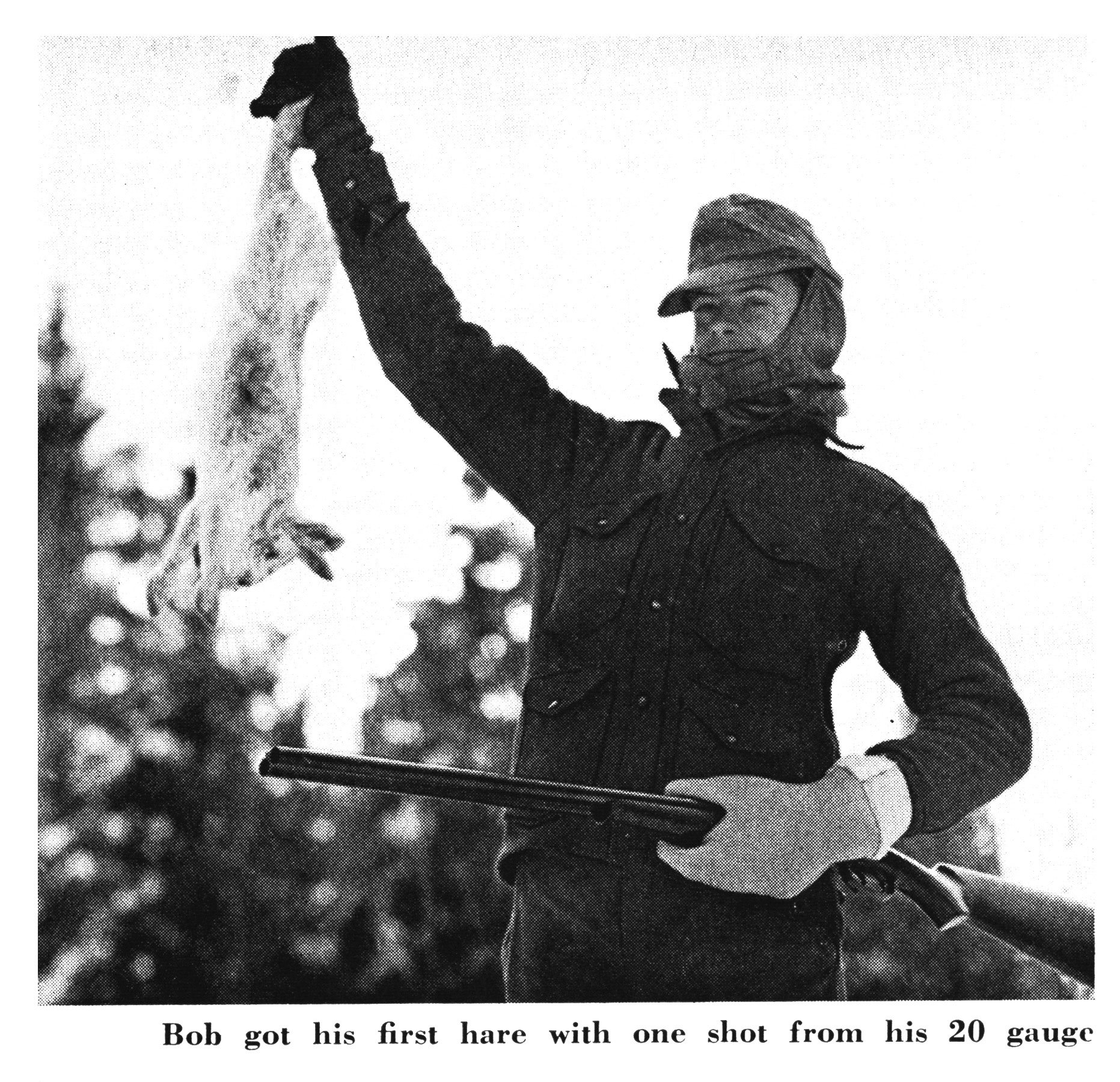 A black and white photo of a boy holding a shotgun and a snowshoe hare.