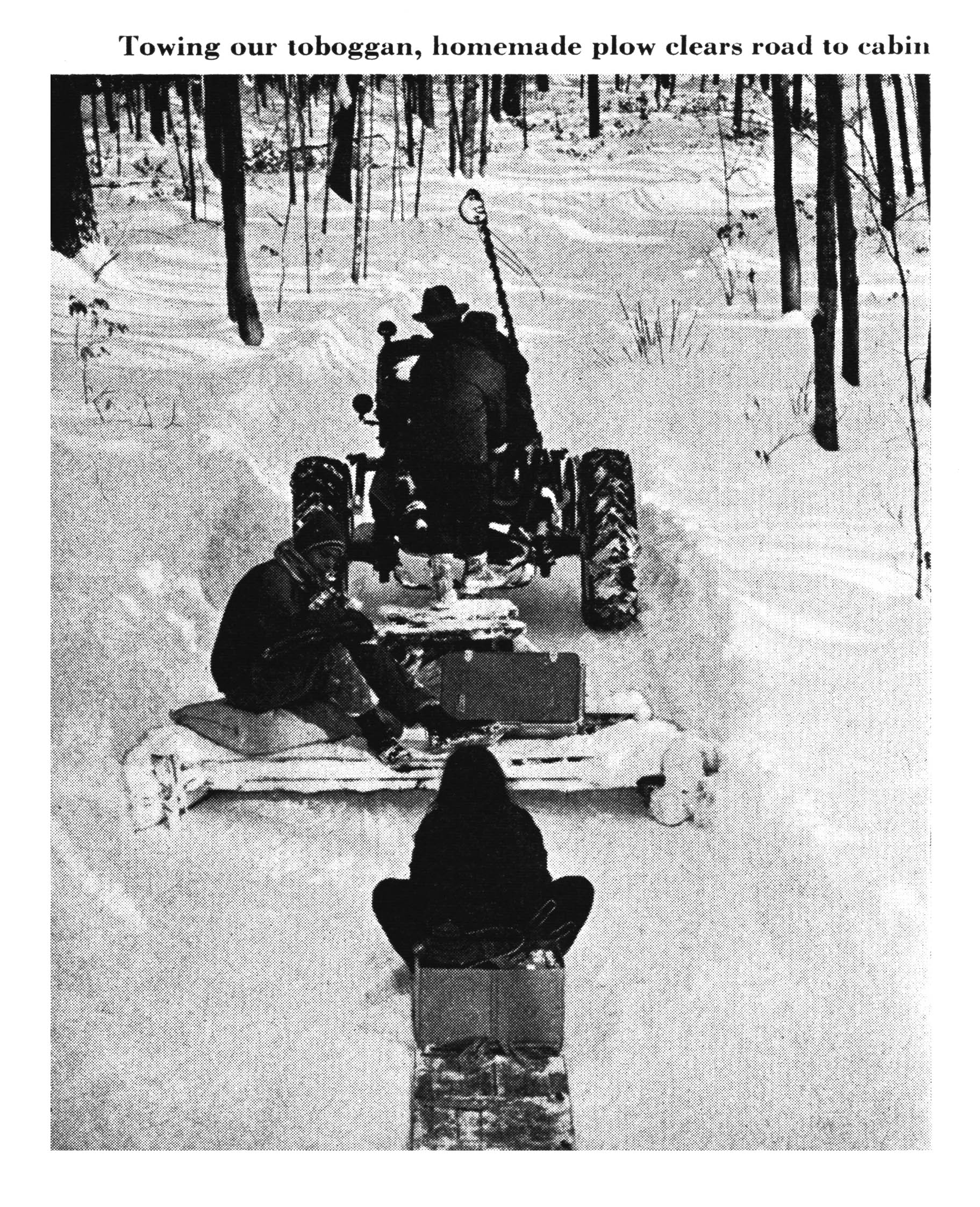 A black and white photo of a tractor hauling people and gear.