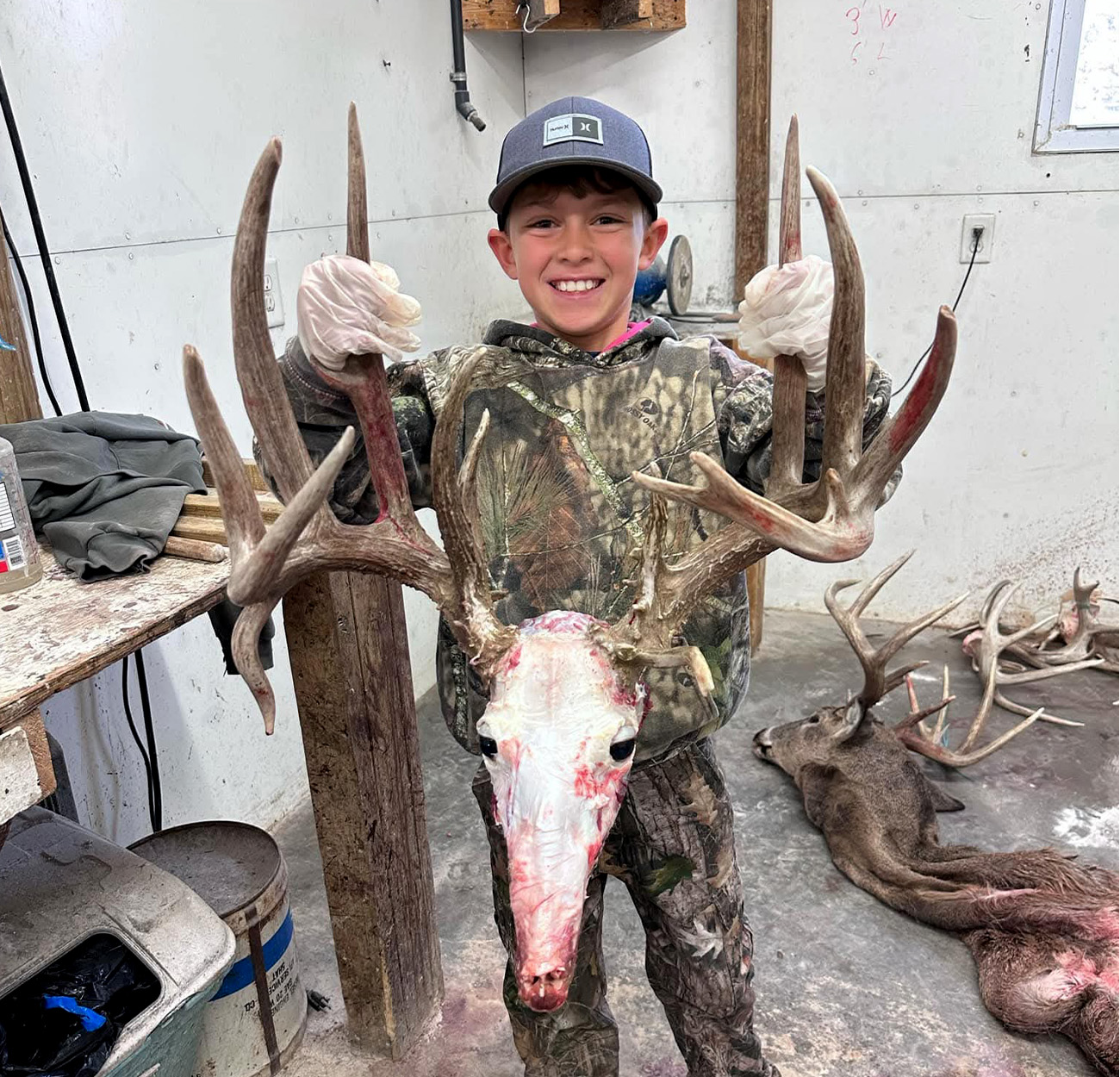 A young hunter with the skull of a whitetail buck.