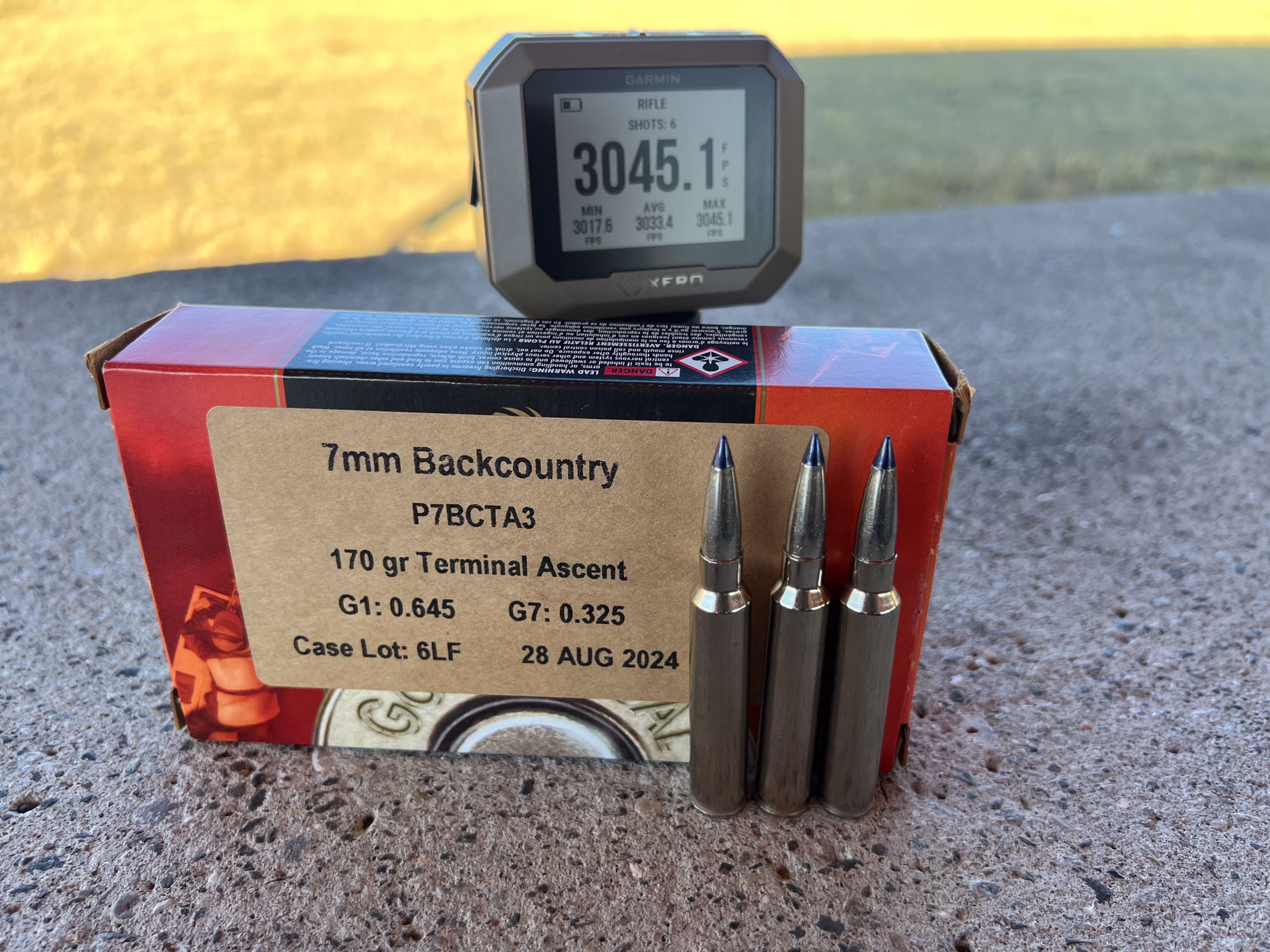 A box of 7mm Backcountry loads sitting in front of a GarminXero chronograph that reads 3045.1