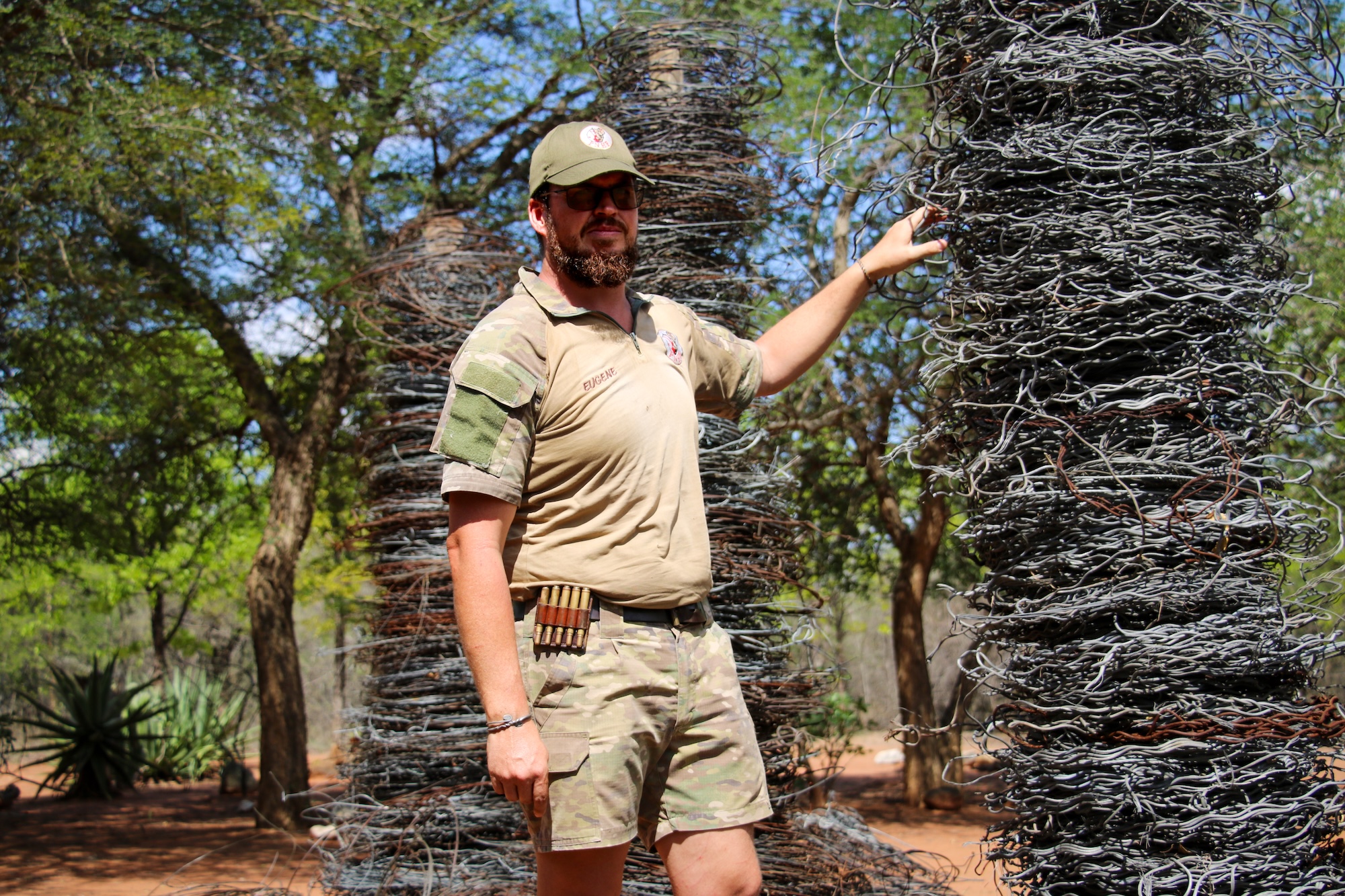 A South African man stands next to piles of snares.