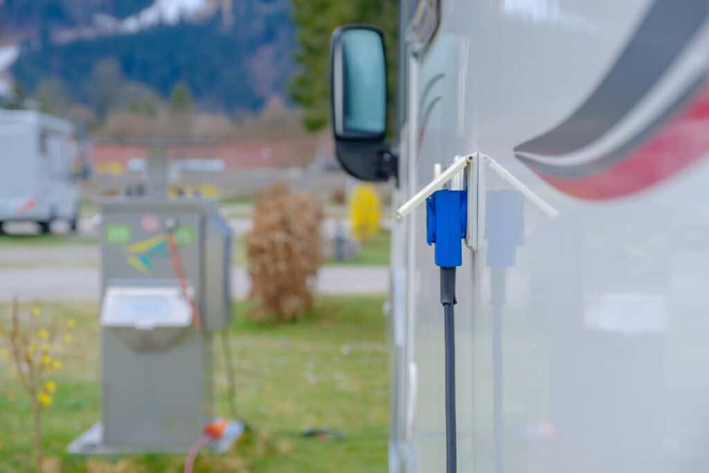 An RV charging in a campsite.