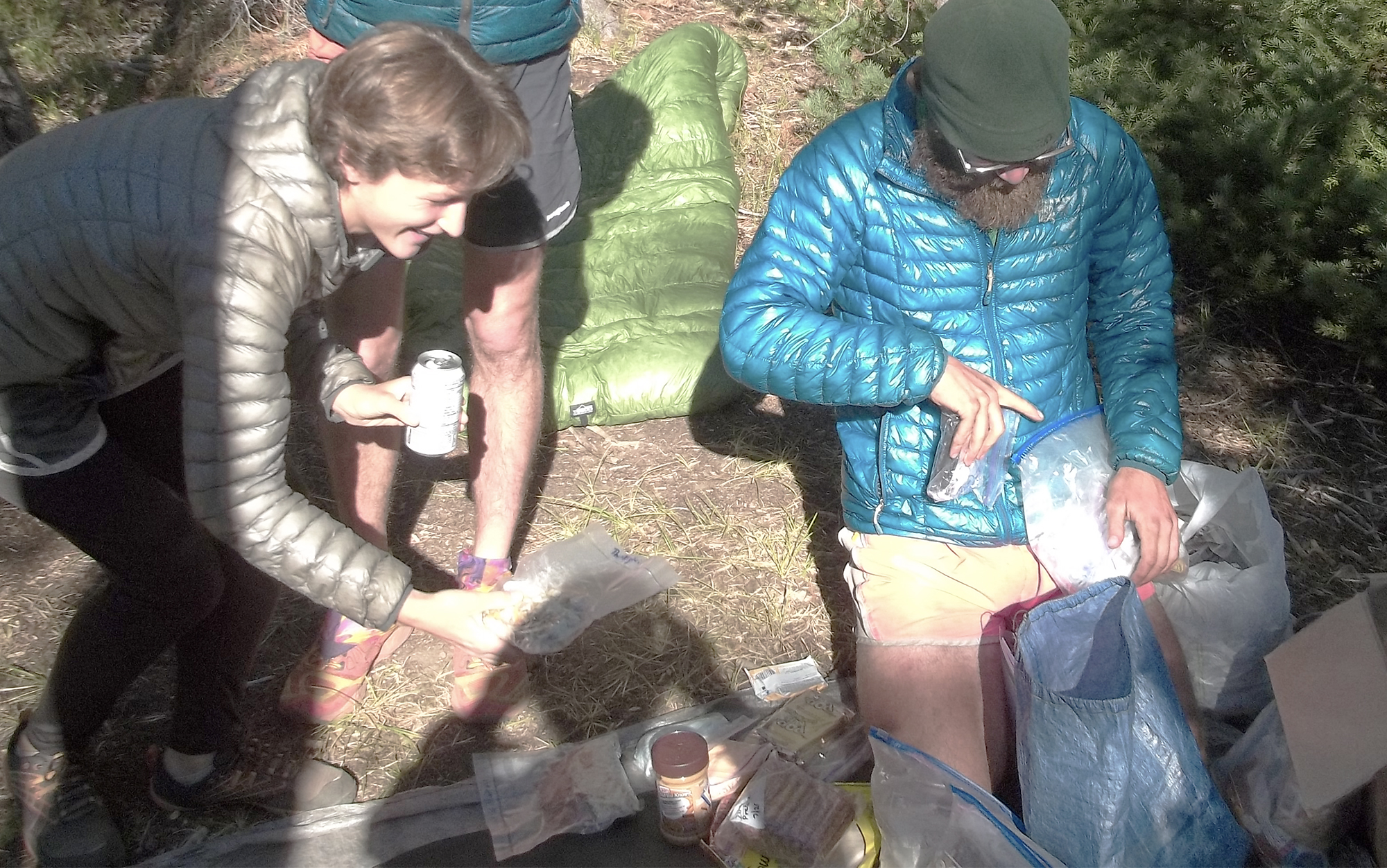 three hikers standing around looking at their resupply