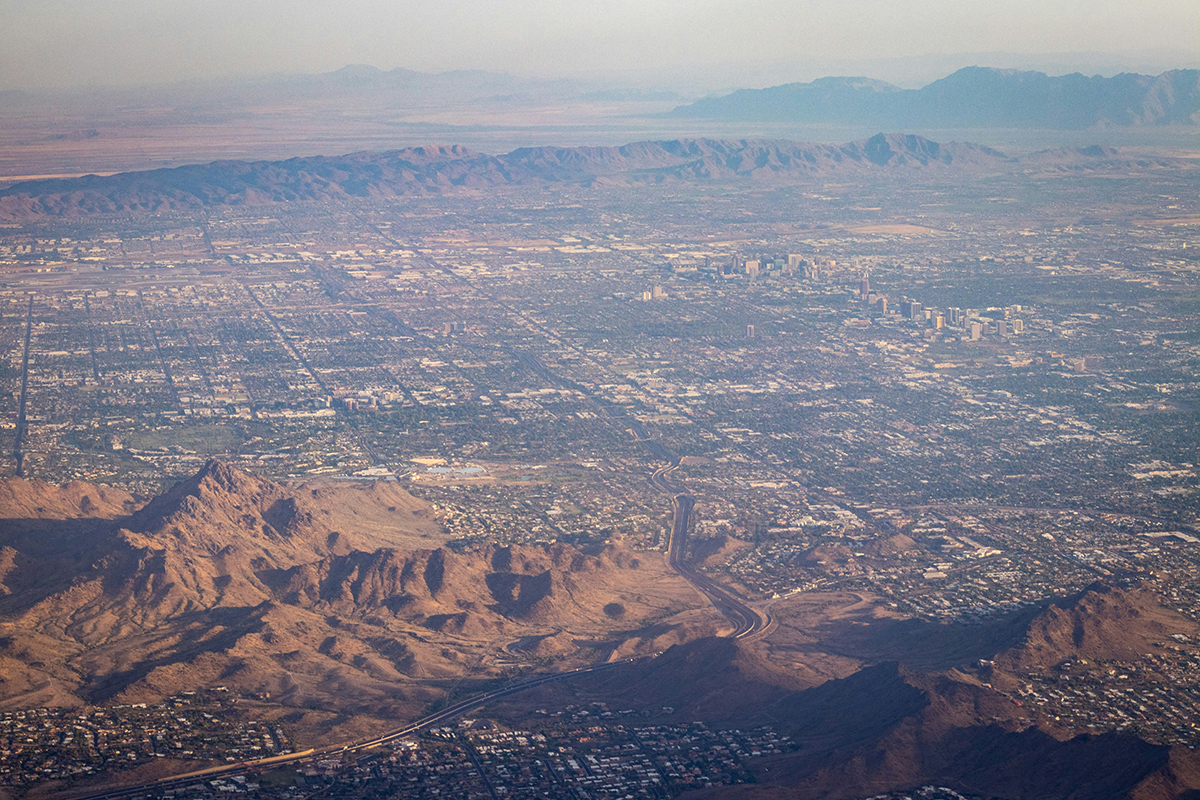 Aerial shot of sprawling city surrounded by mountains.