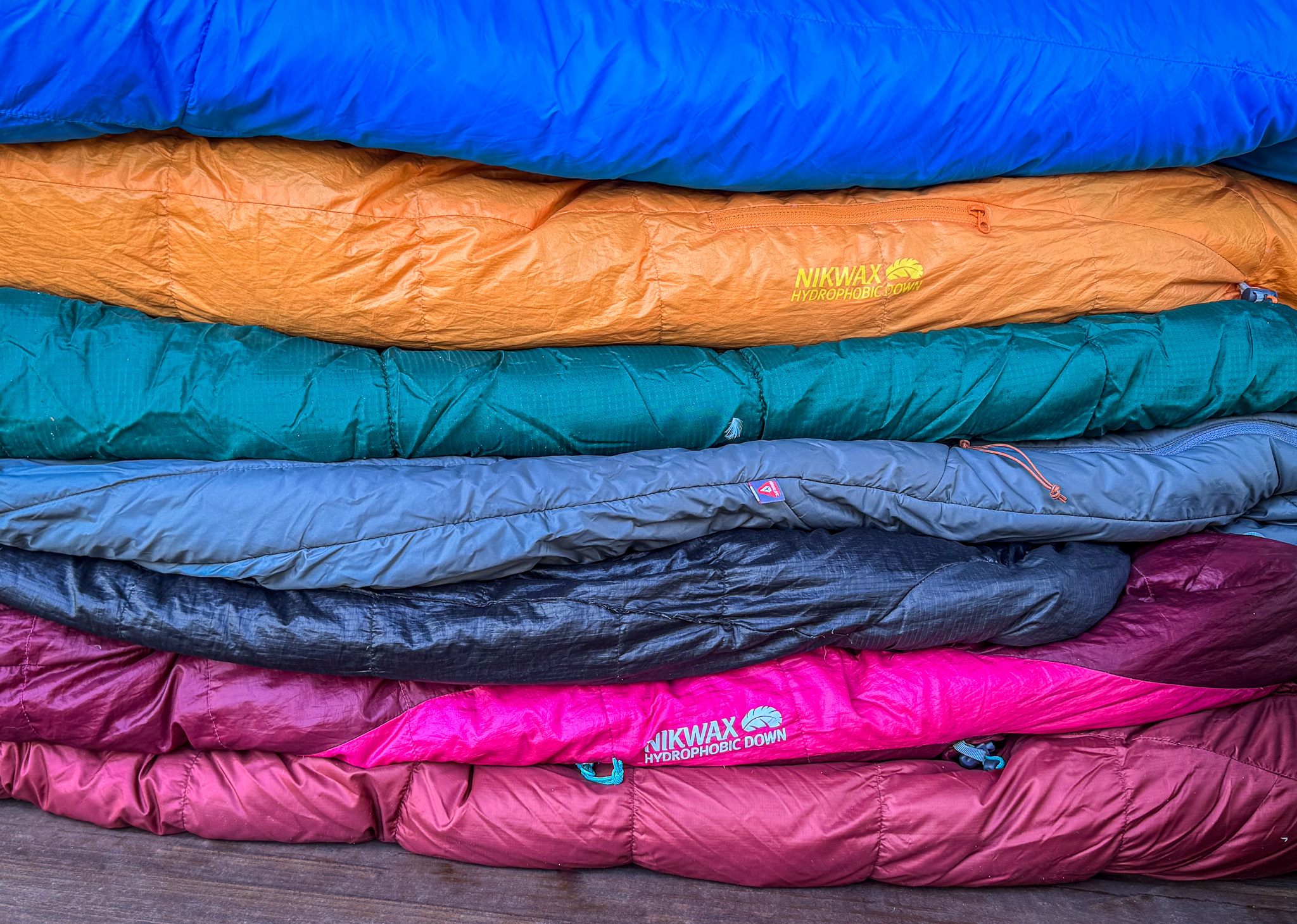 A stack of down and sythentic sleeping bags.