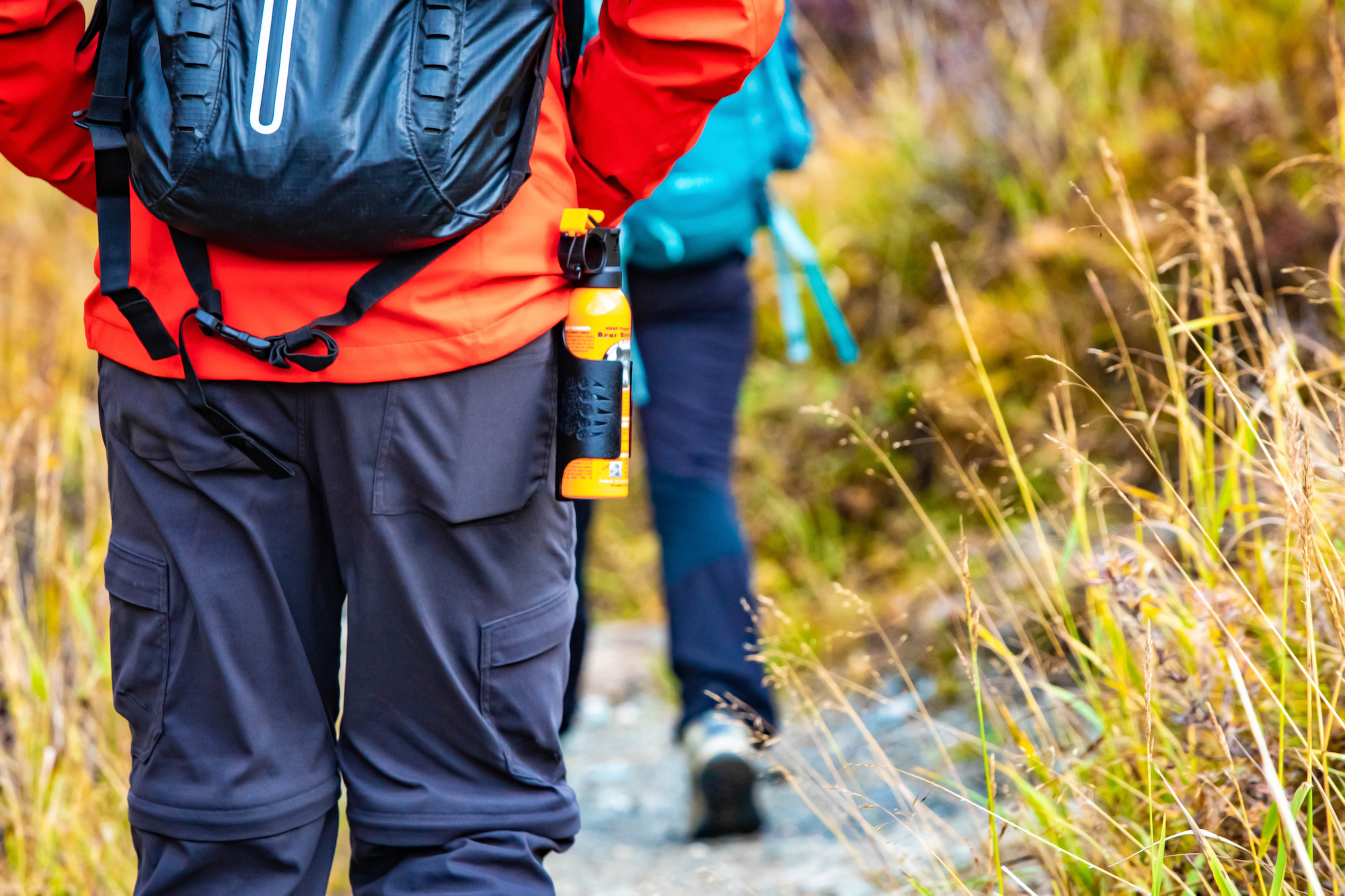 a hiker carries bear spray on their hip