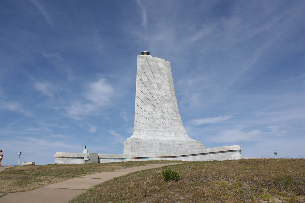 Concrete spire against blue sky with light clouds is a historic site.