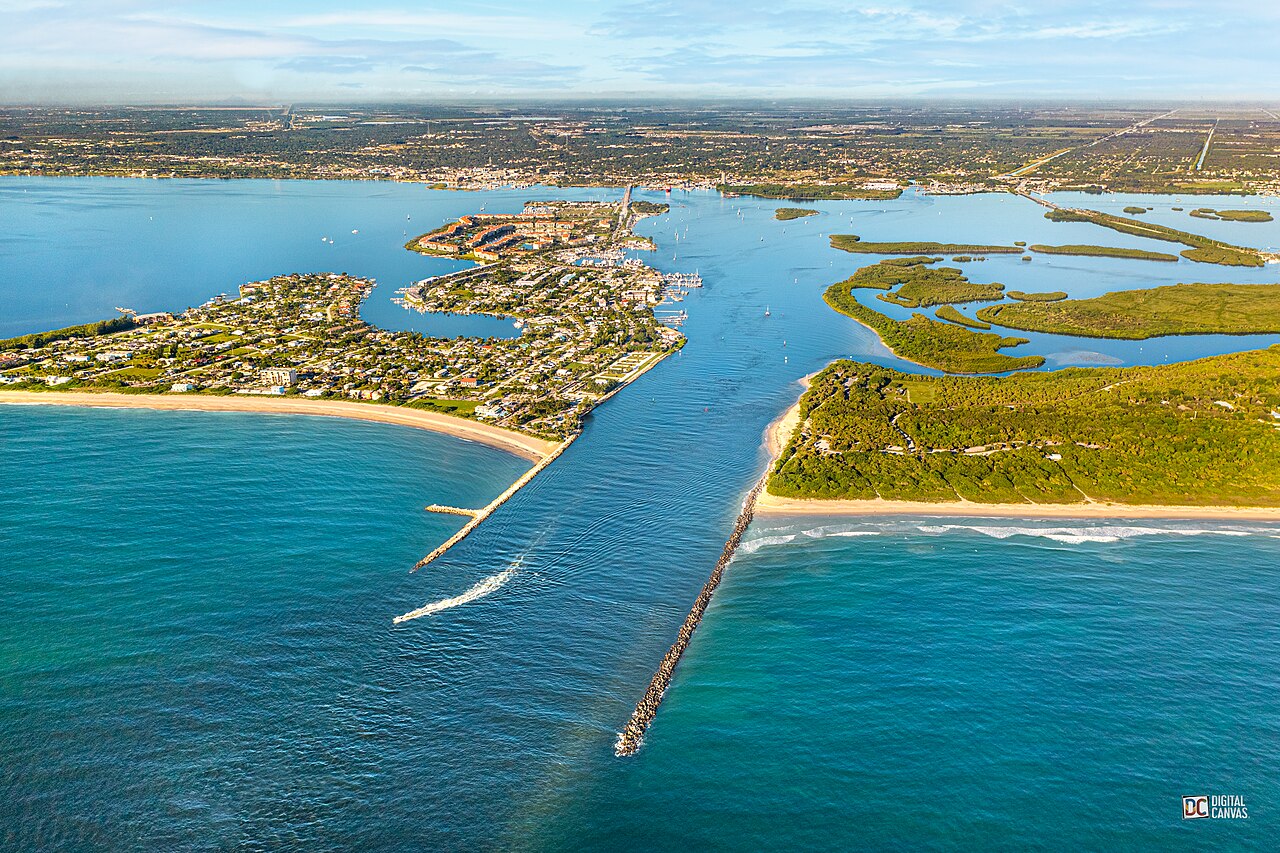 Aerial shot of ocean inlet leading to verdant park.