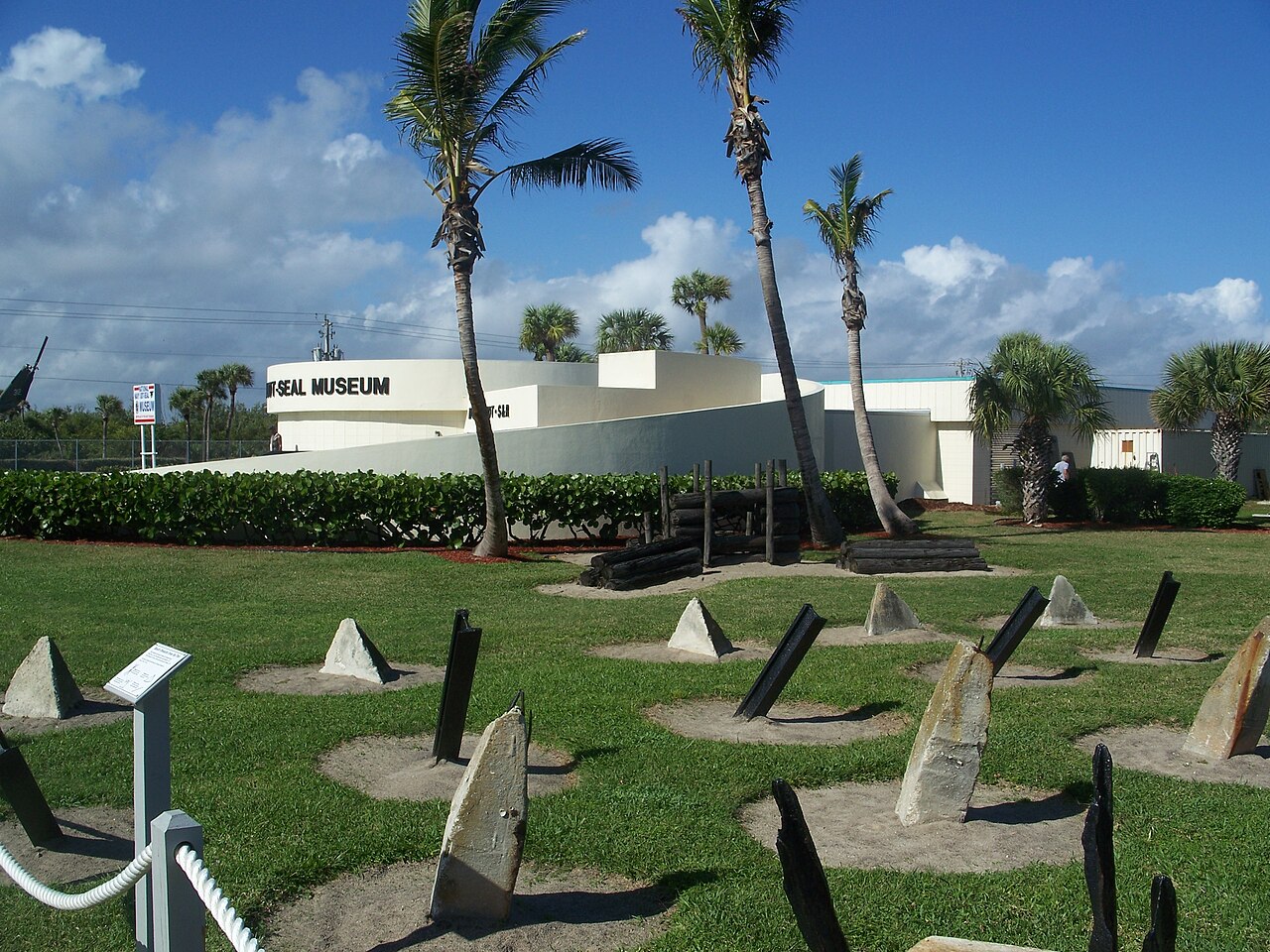 White museum in background, military obstacles in foreground.