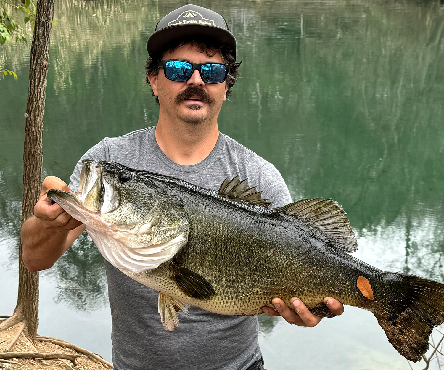 An angler holds up a giant bass in Austin, Texas.