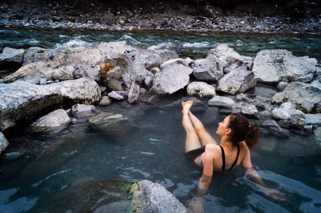 A woman enjoying a soak in a natural hot spring.. 