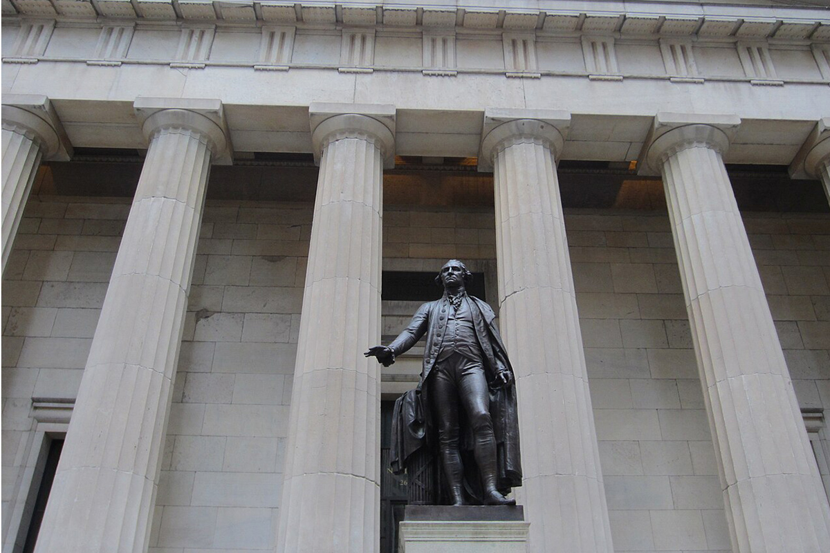 Bronze statue of man in front of building with pillars.