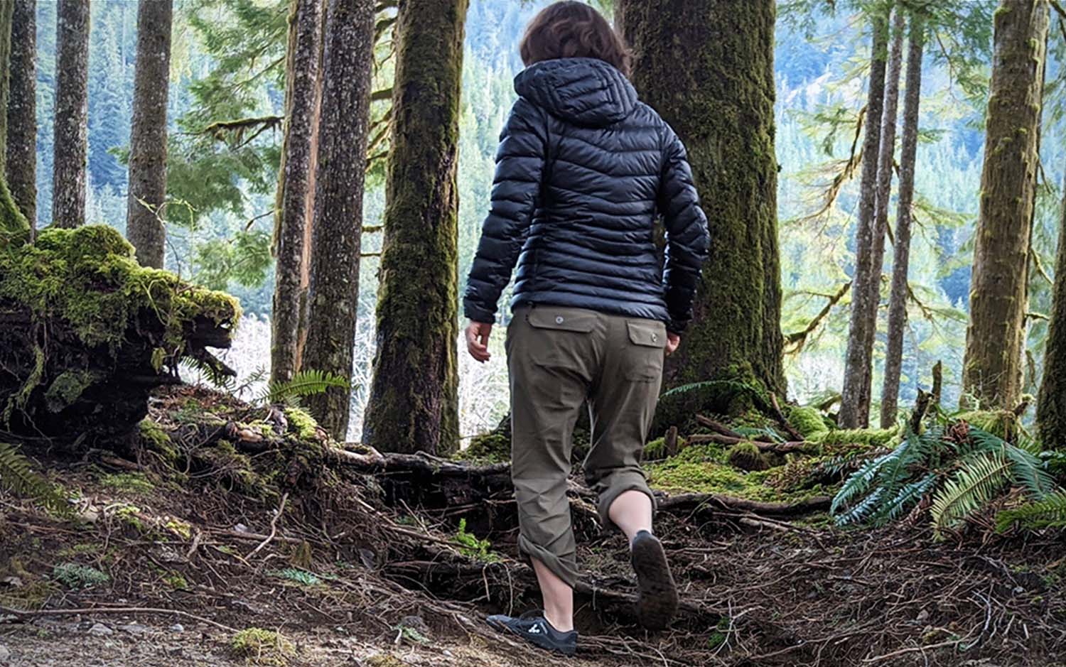 A woman walking through the woods.