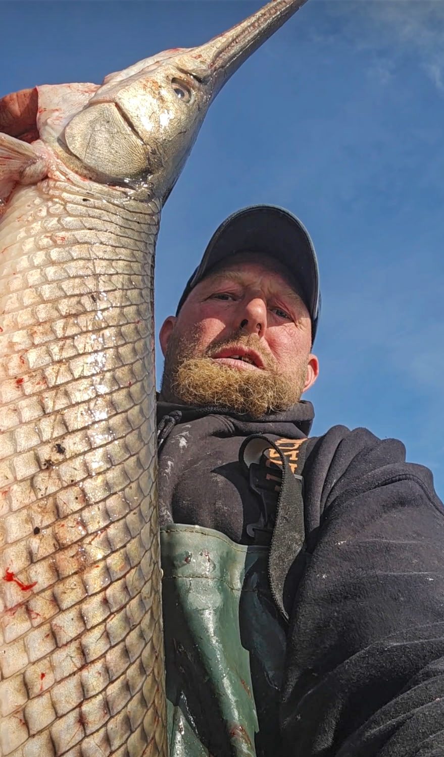 A man holds up a gar.