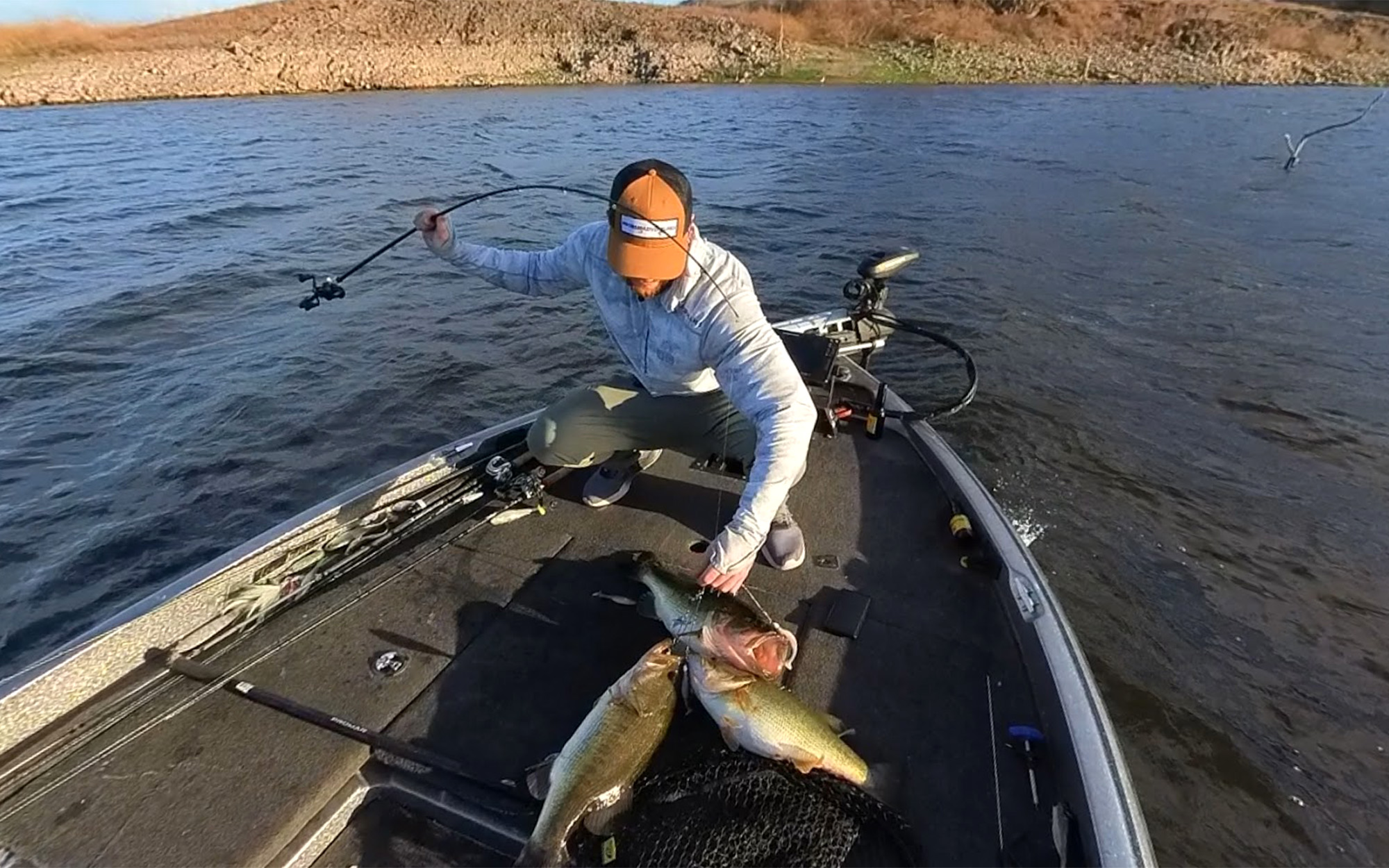 An angler unhooks the three bass he caught on one cast.