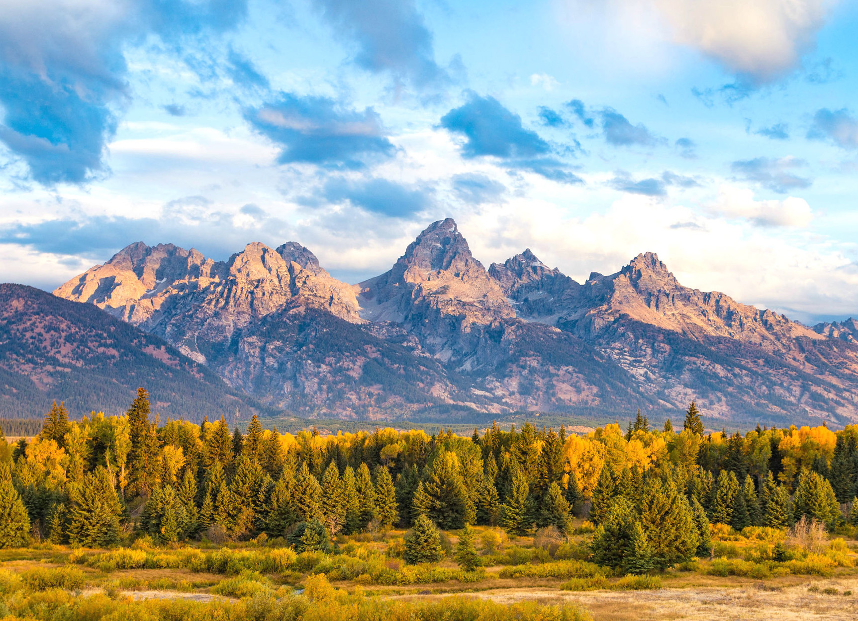 The Teton Mountains under a blue sky.