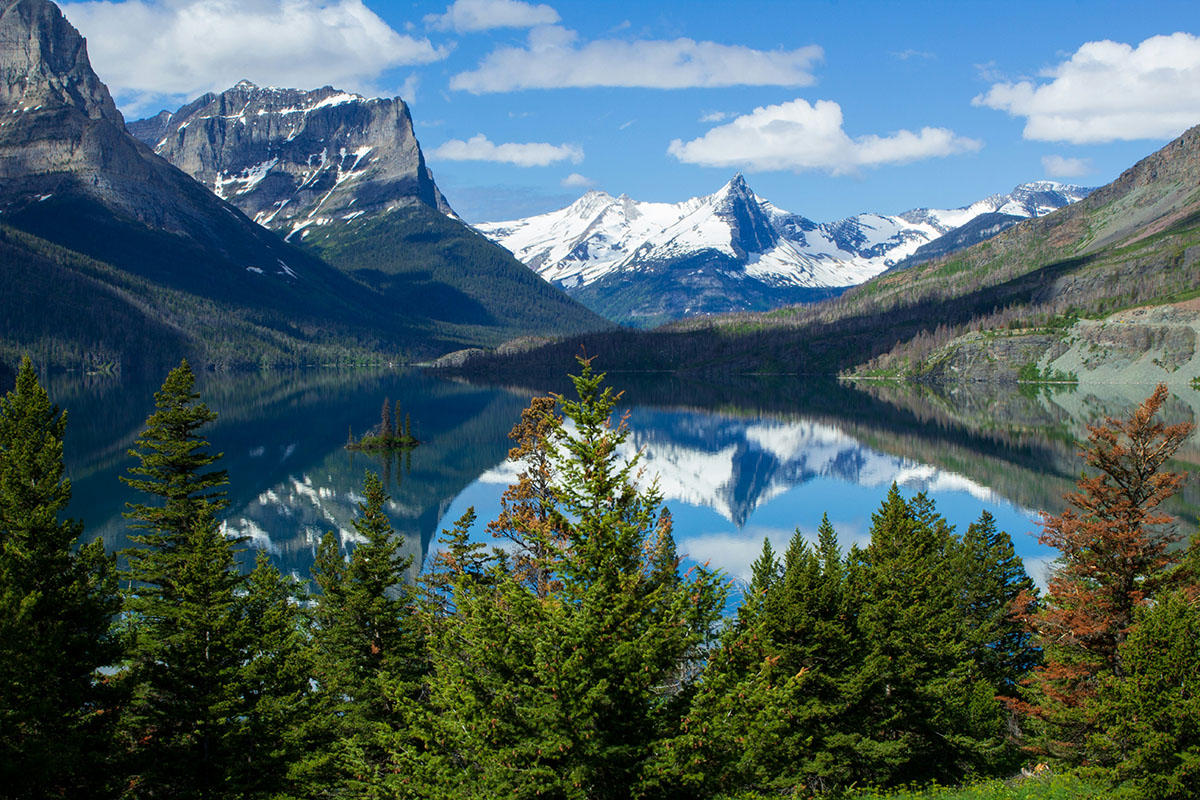 Clear lake reflects snow-capped peaks.