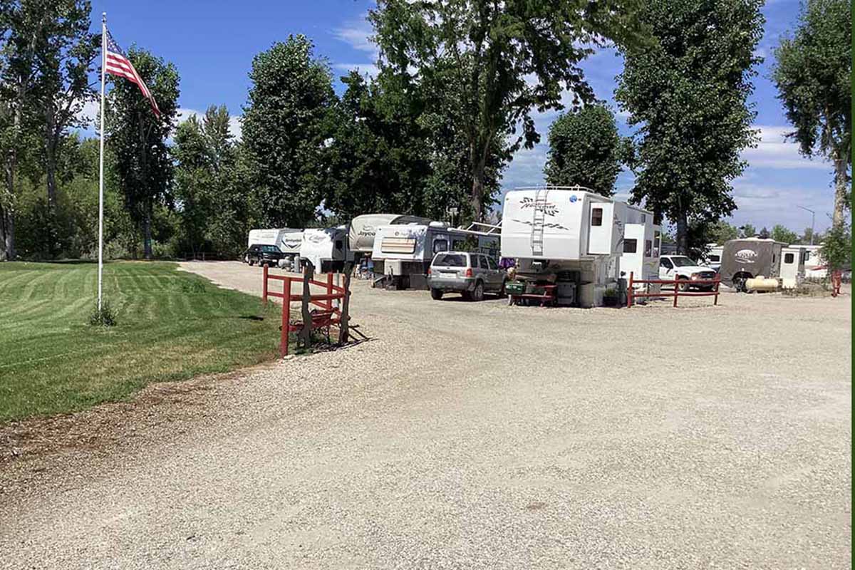 RVs in a campground setting with American flag.