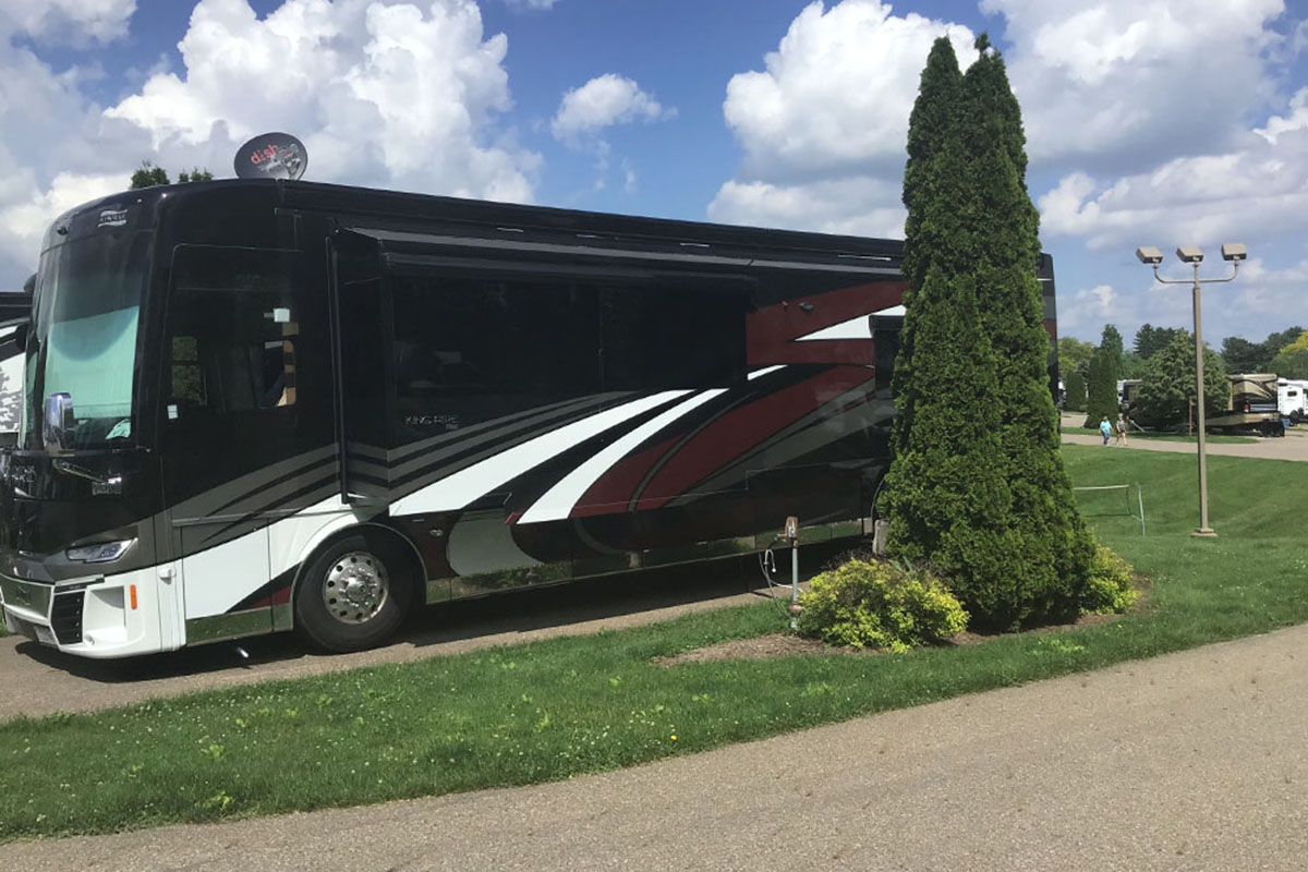 Motorhome under blue sky in RV site.