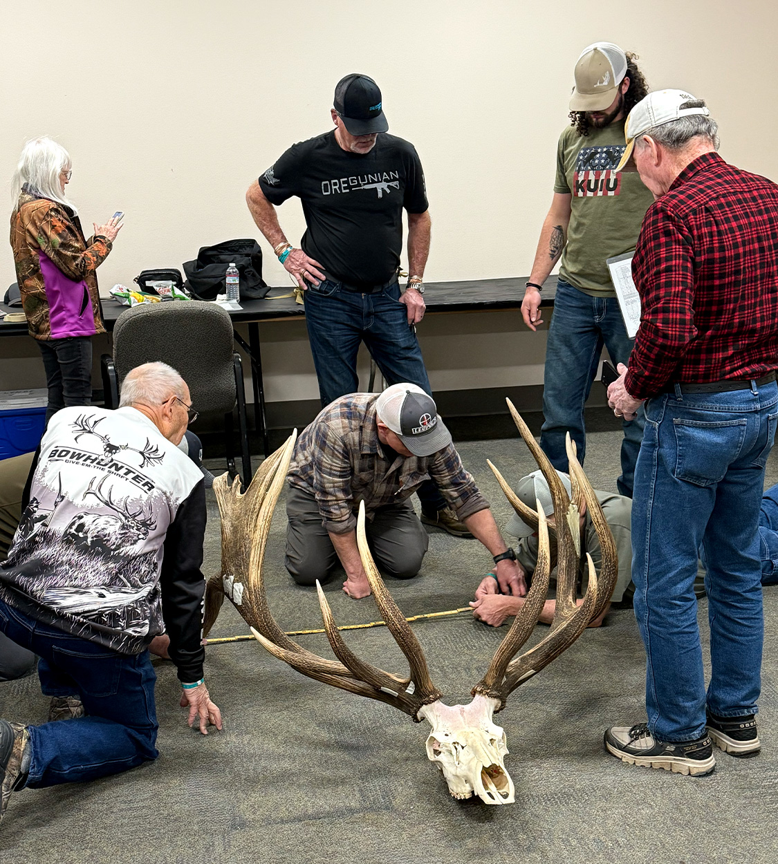 Official scorers with Pope & Young measure a set of giant elk antlers.