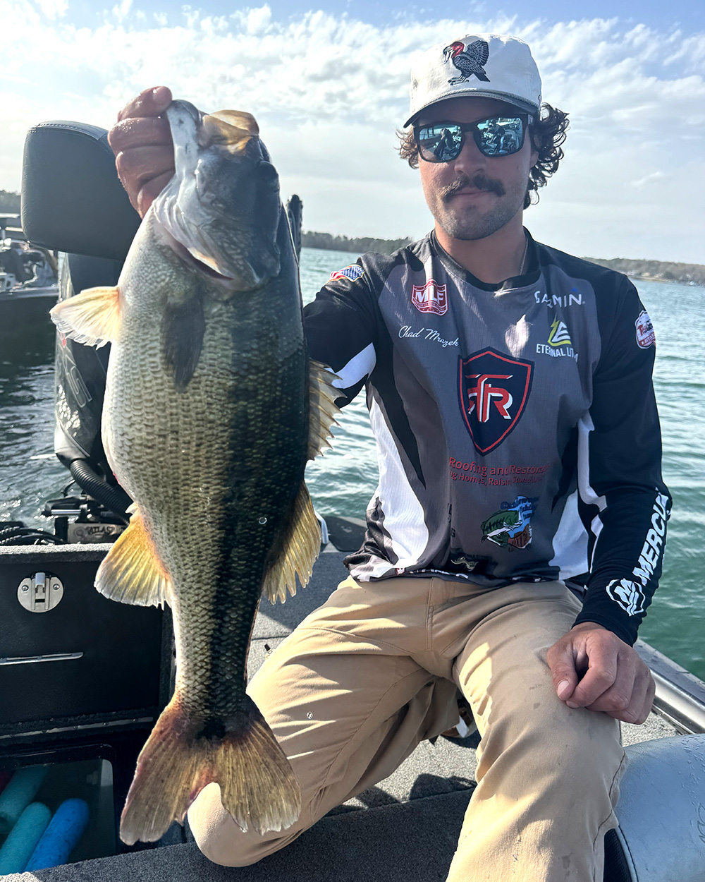 A tournament angler holds up a fat spotted bass on Lake Hartwell.