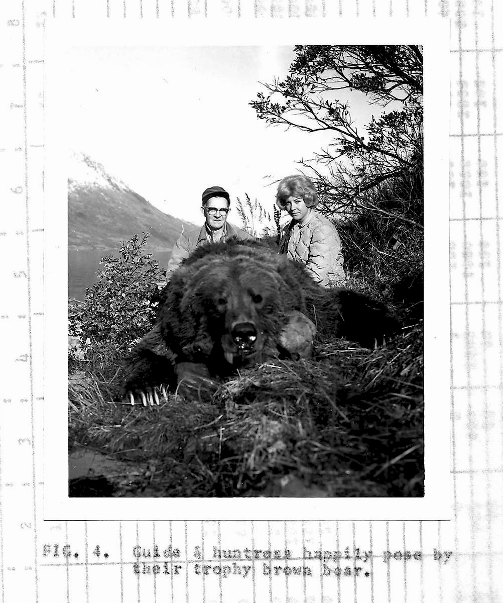 A vintage black and white photo of a woman who hunted a brown bear beside her guide.