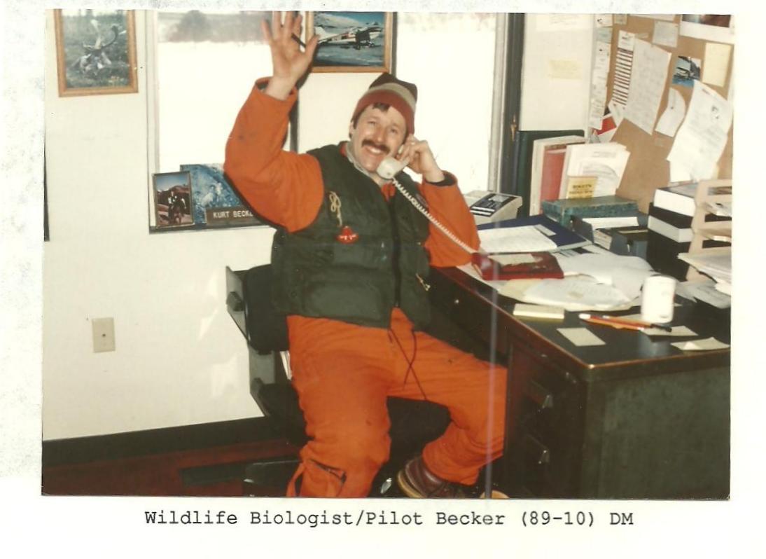 A pilot waves from his desk.